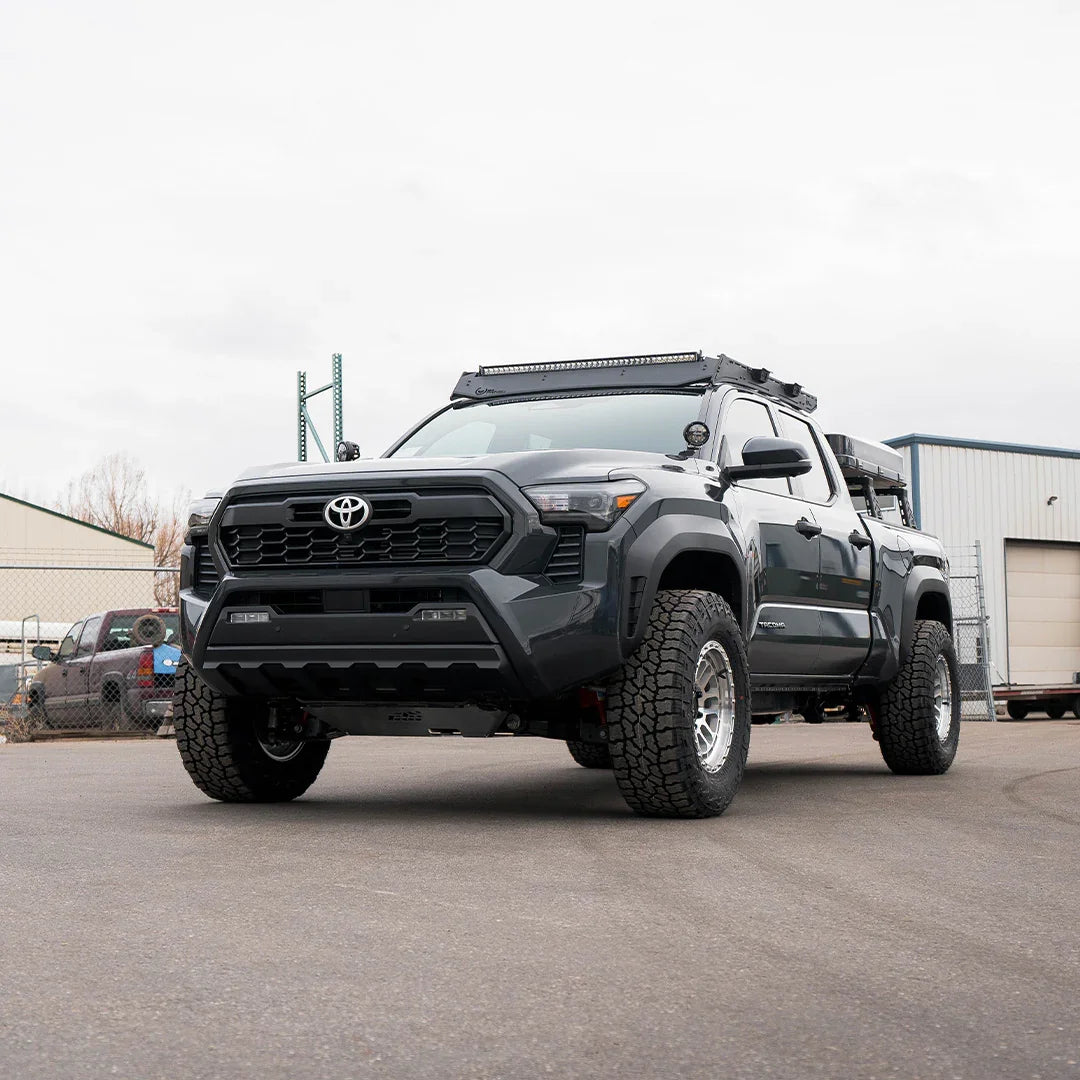 4th gen Toyota Tacoma with heavy-duty skid plates and off-road accessories parked outdoors