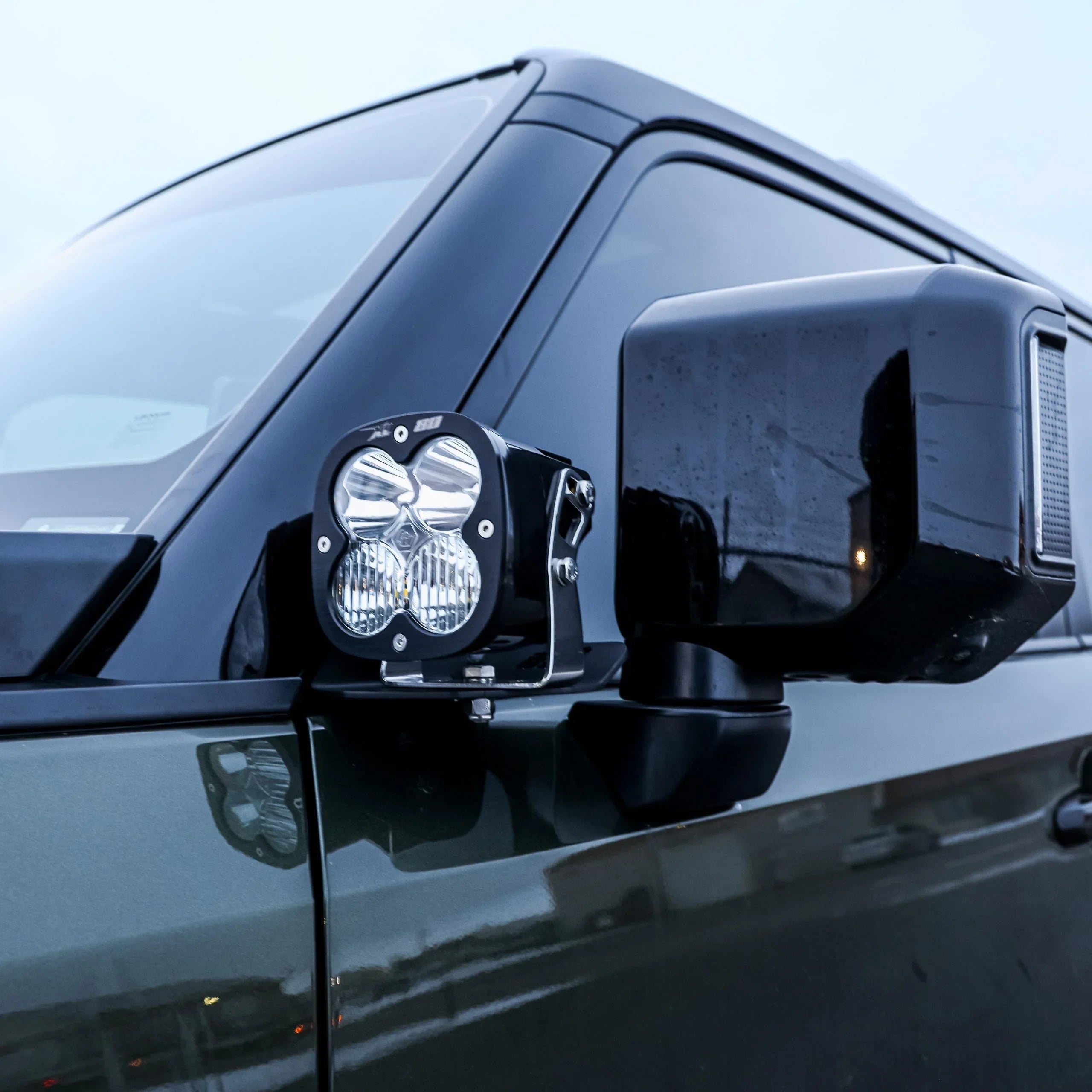 LED ditch light mounted on vehicle side mirror for overlanding and off-road visibility