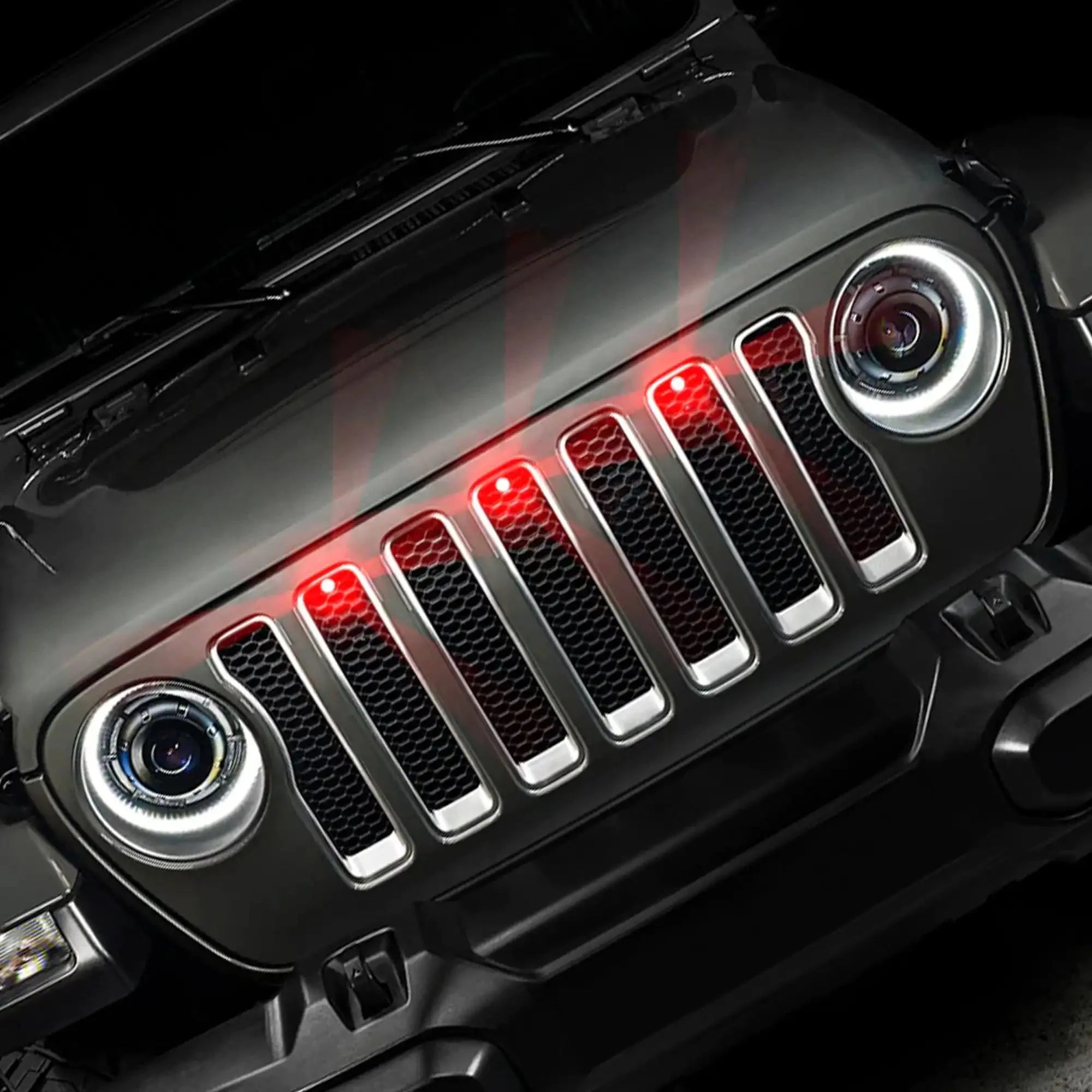Front view of Jeep grille with illuminated red LED lights and halo headlights, vehicle accessory