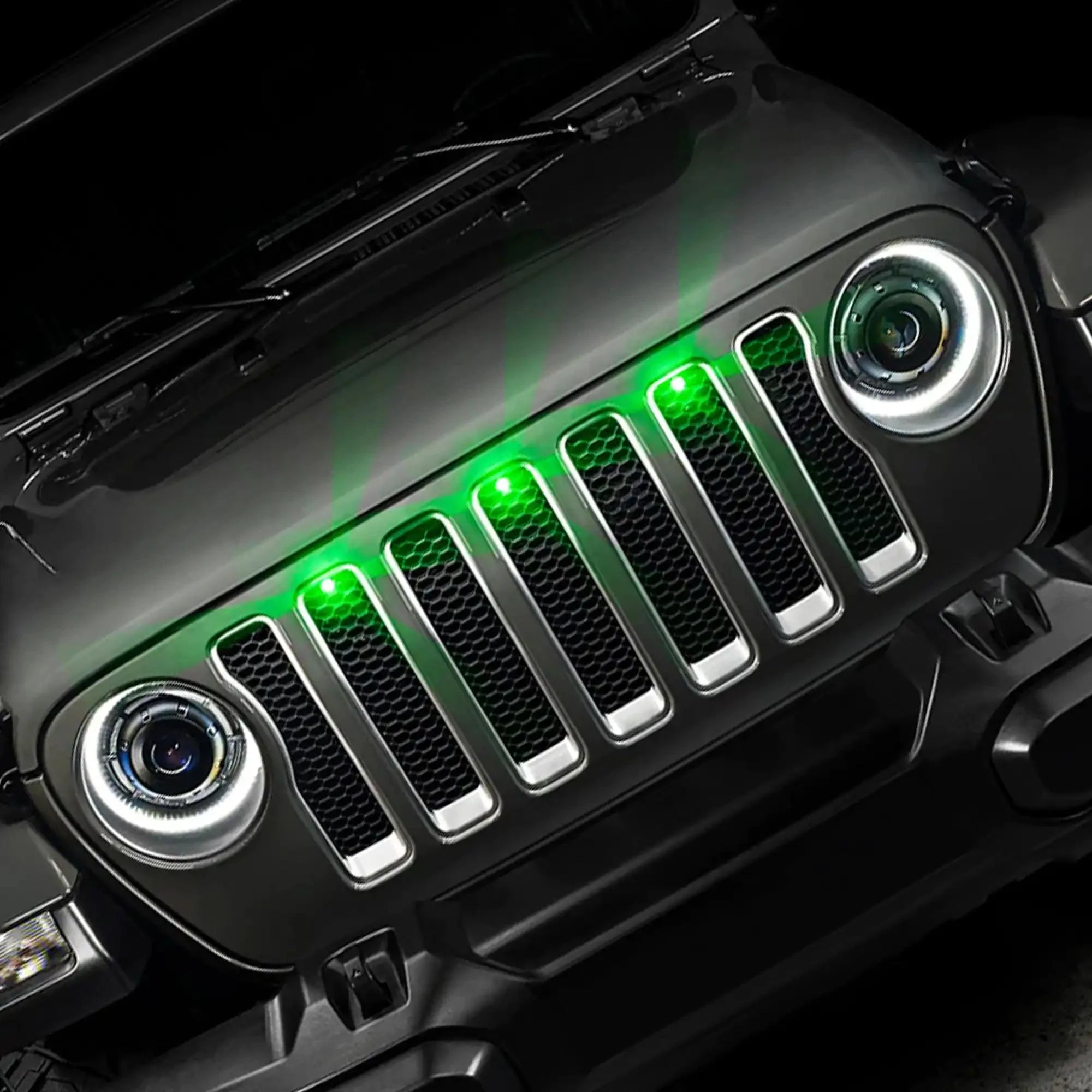 Front grille of Jeep with green LED accent lights and round headlights, overlanding accessory