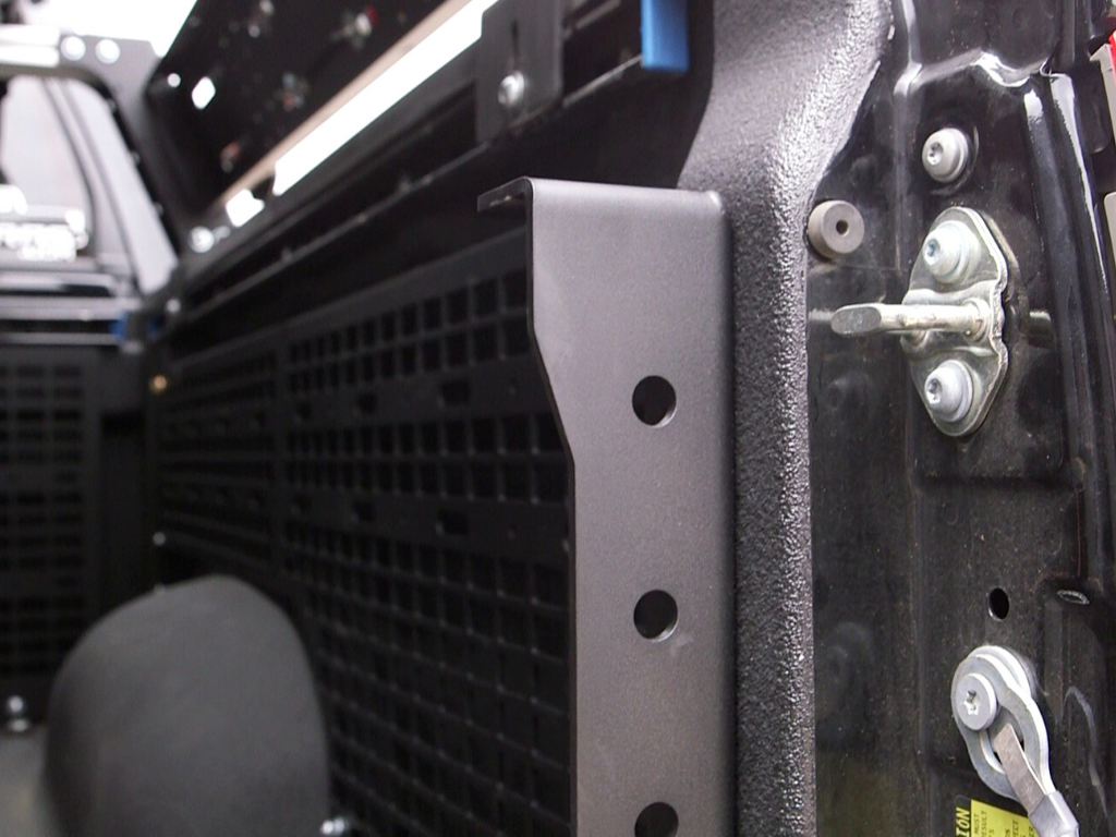 Close-up of modular truck bed rack panel and mounting bracket for overlanding gear
