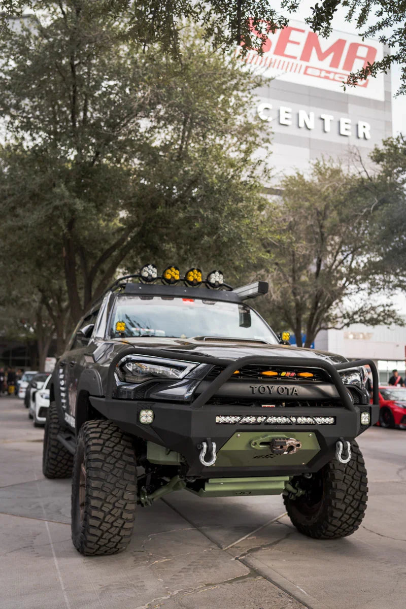 Lifted Toyota 4Runner with off-road bumper, winch, and roof lights at outdoor expo