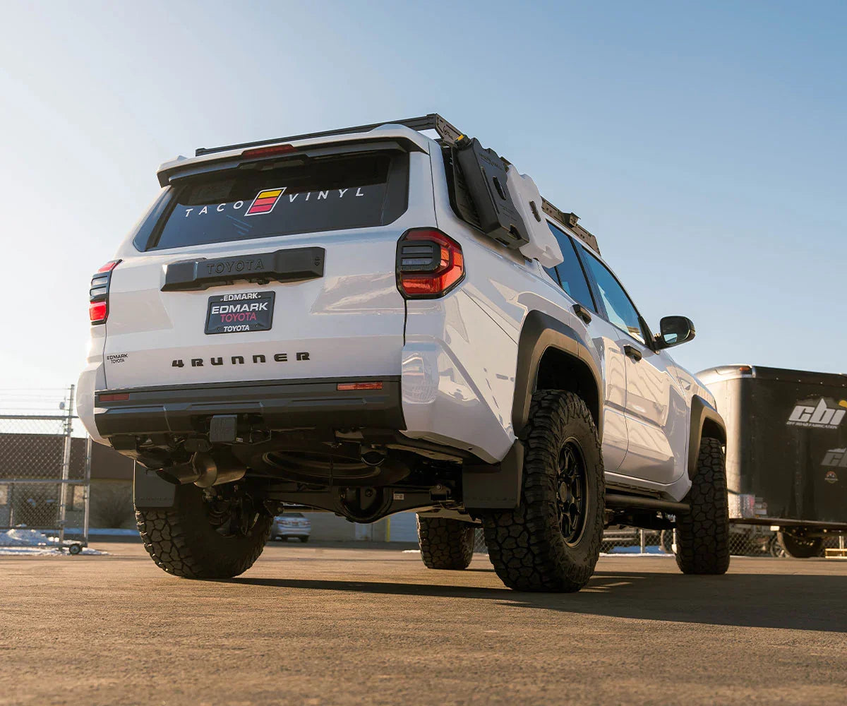 White Toyota 4Runner with off-road tires and overlanding gear in parking lot