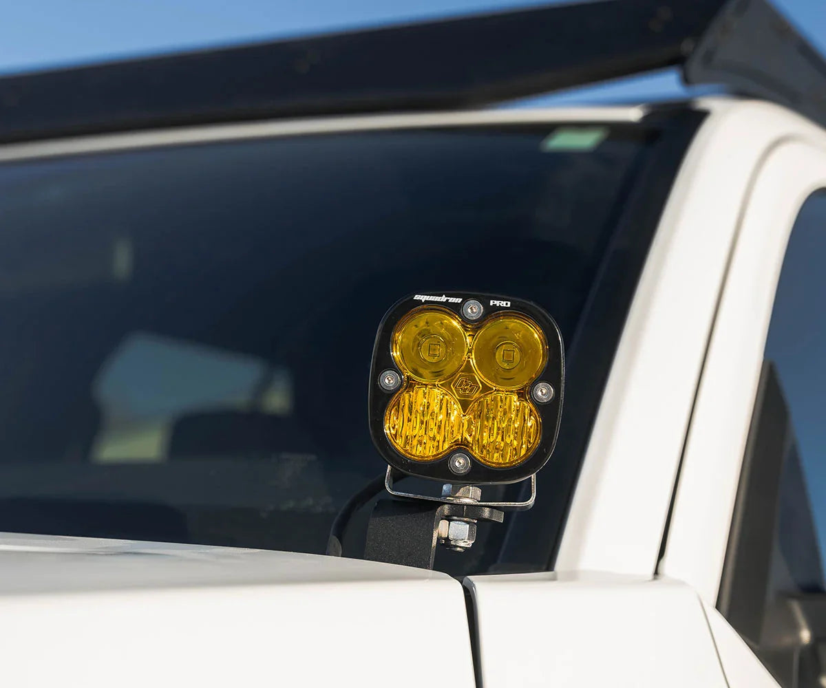 Close-up of yellow off-road LED pod light mounted on white Toyota 4Runner windshield