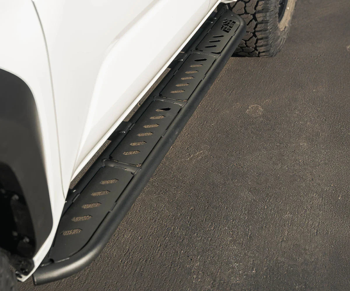 Black steel rock slider and step mounted on Toyota 4Runner for off-road protection