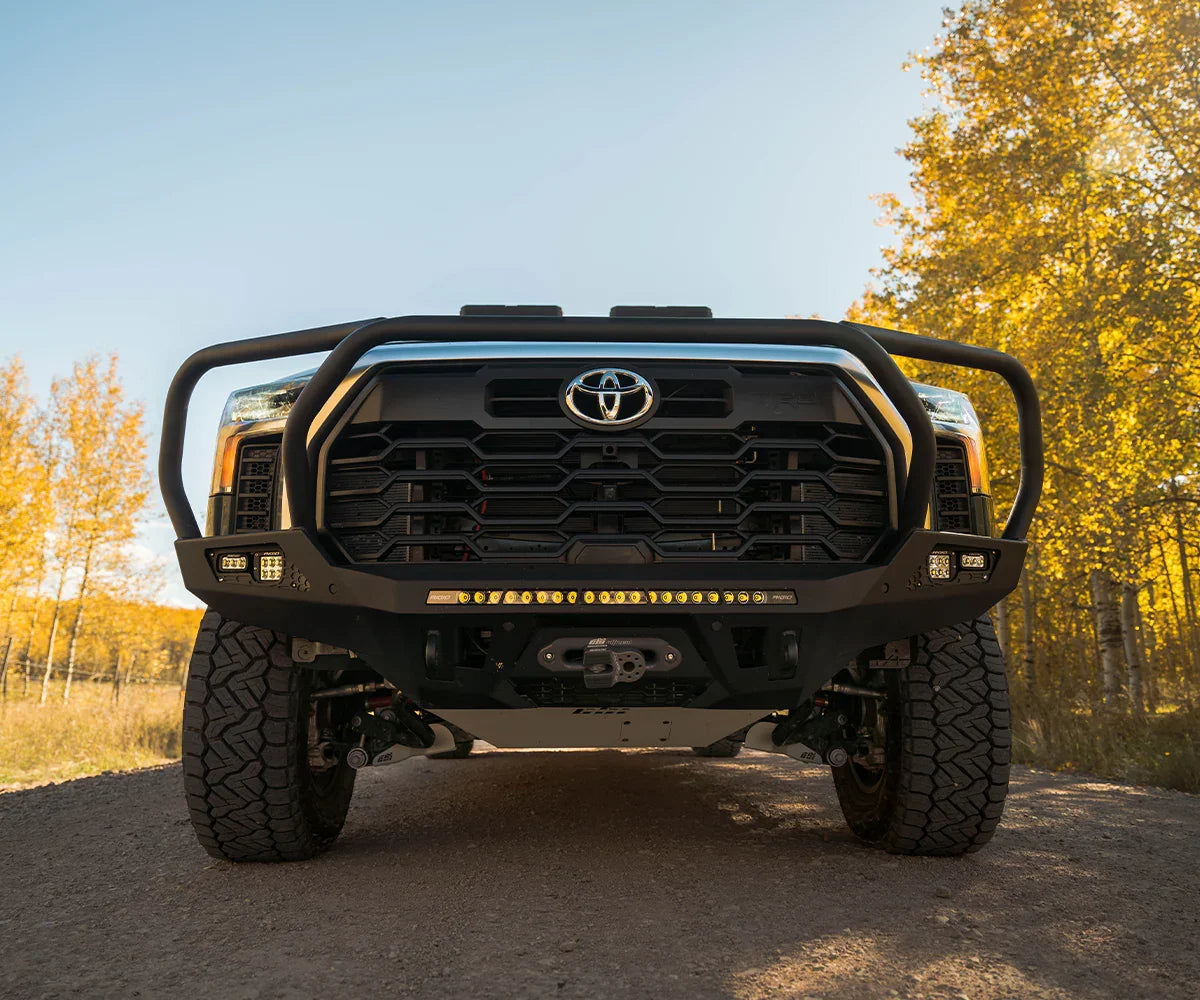 Front view of Toyota Tundra with off-road adventure series steel bumper on a forest trail