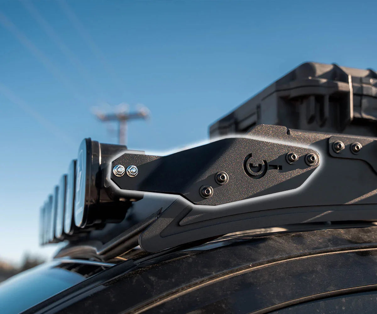 Aluminum light bar bracket mounted on vehicle roof rack for overlanding gear