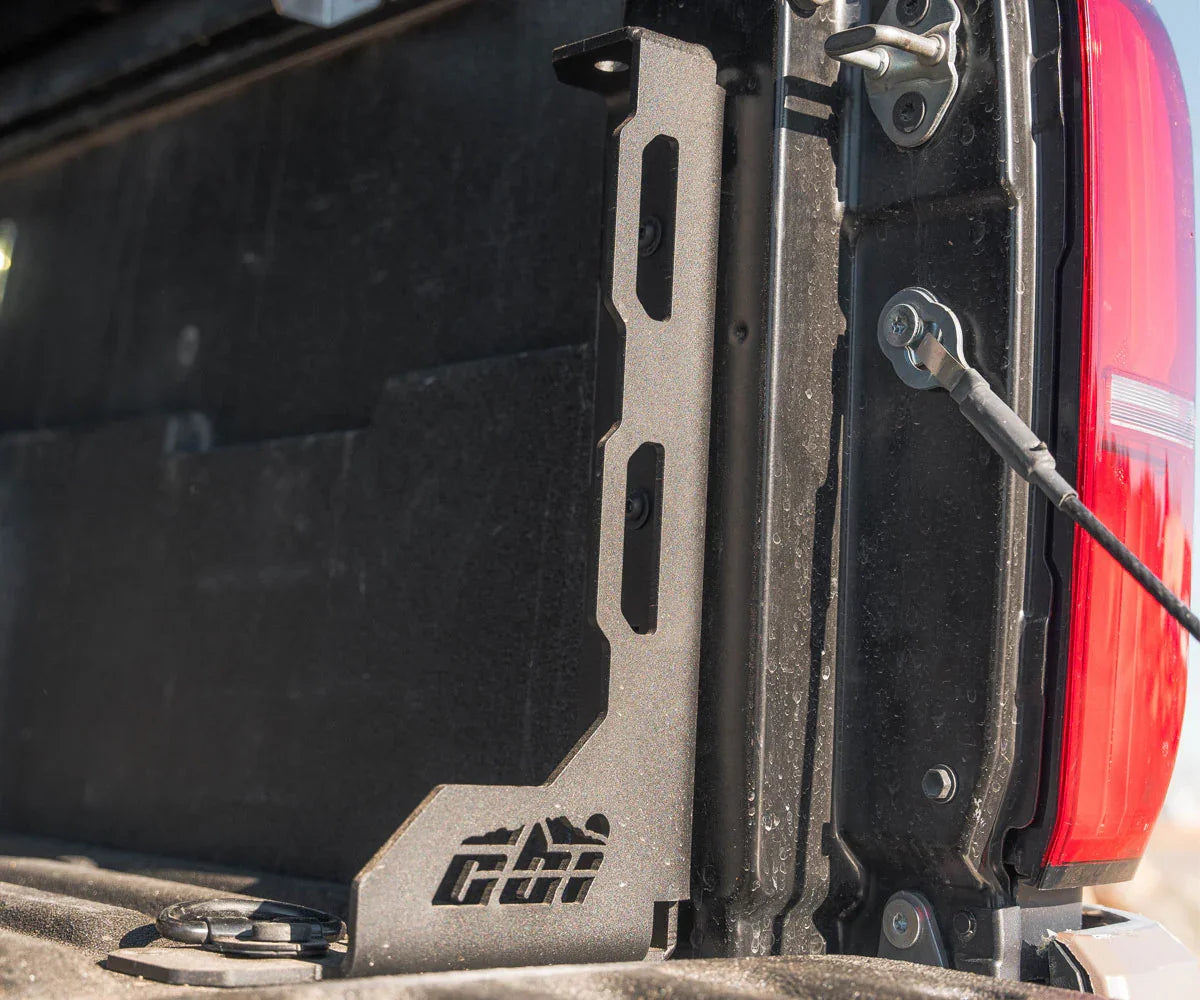 Truck bed accessory mounting bracket installed on pickup tailgate, close-up view