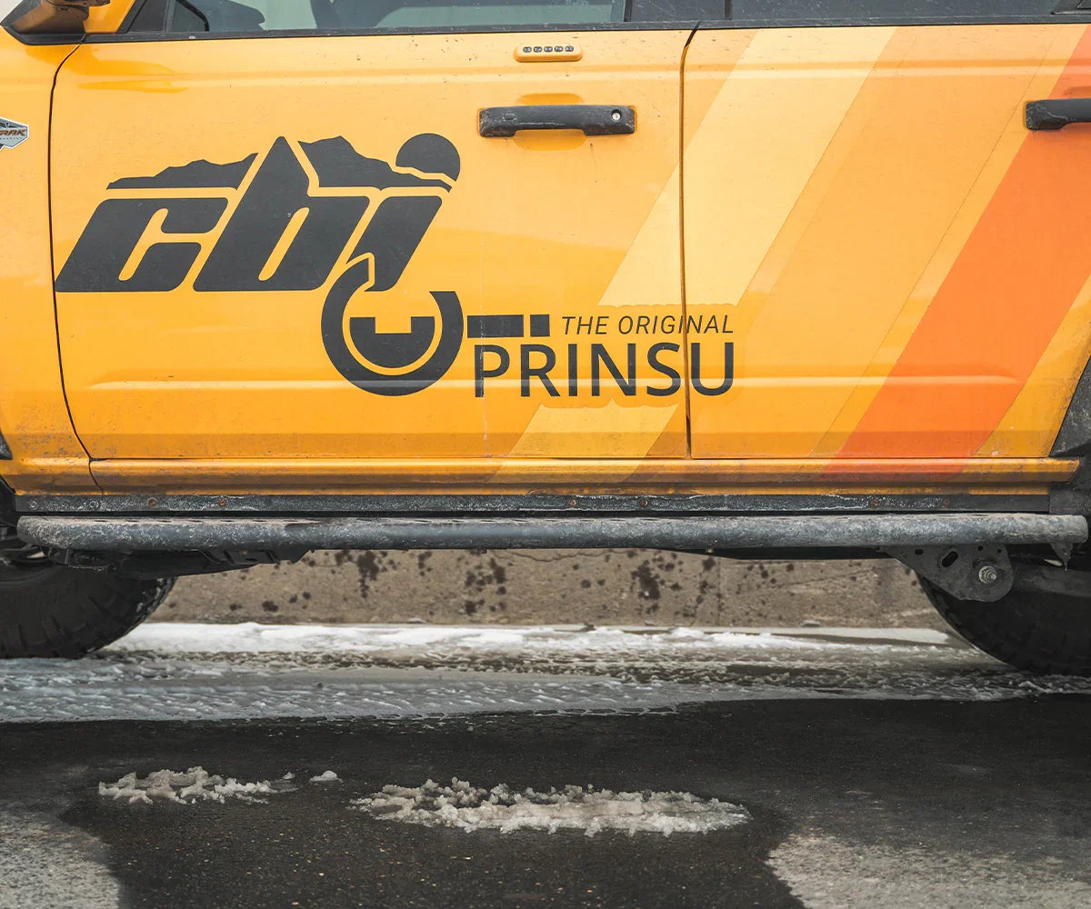 Bolt-on rock sliders with weld cover on a yellow off-road vehicle