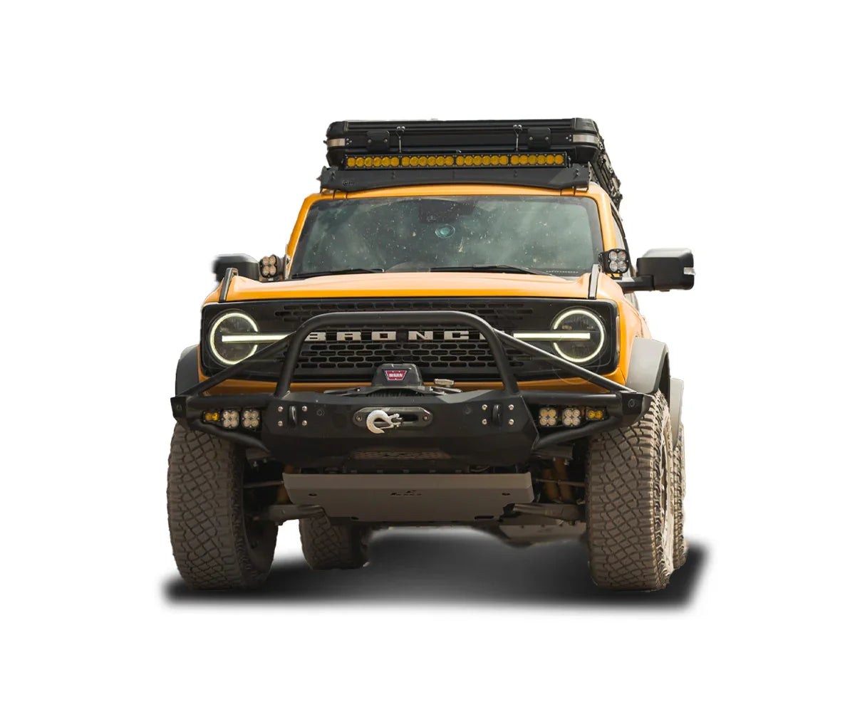 Front view of yellow Ford Bronco with off-road bumper, roof rack, and adventure gear