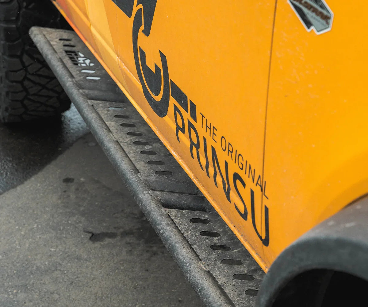 Bolt-on rock sliders installed on yellow Ford Bronco for off-road protection