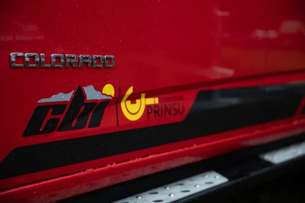 Close-up of CBI Colorado ZR2 side steps on red truck with distinct CBI and Prinsu logos.