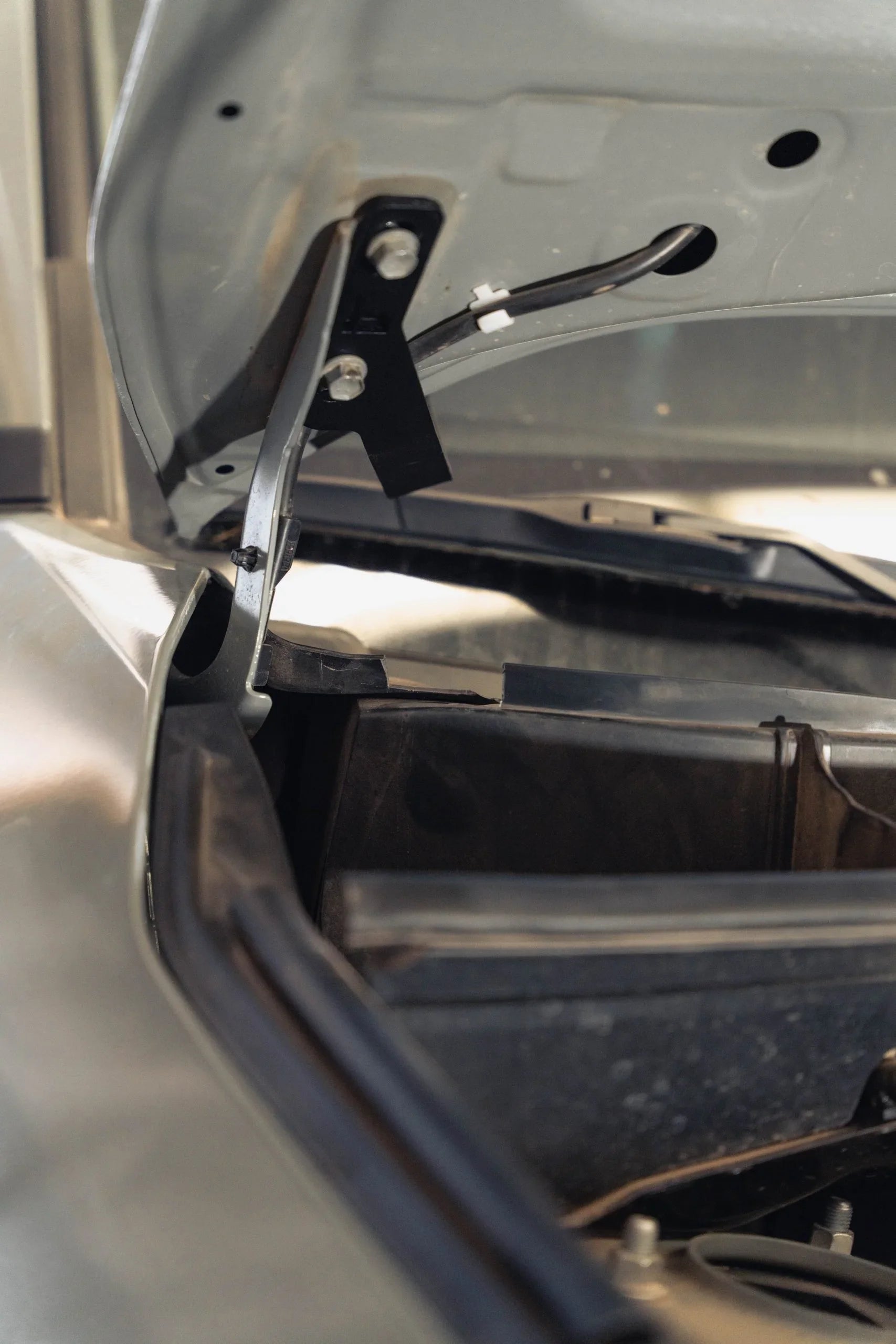 Toyota RAV4 ditch light bracket mounted under hood, close-up installation view