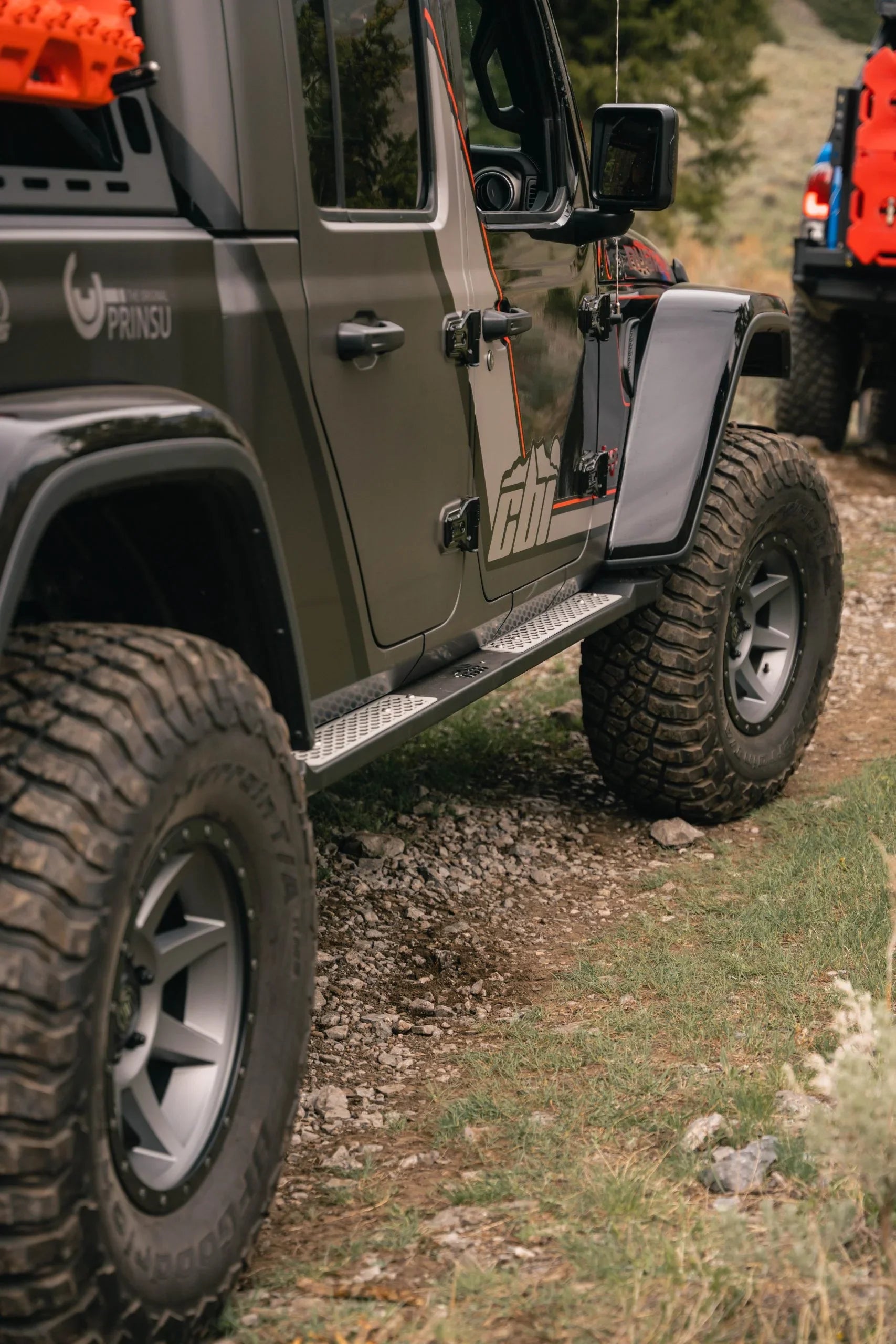 Jeep Gladiator with off-road tires and gear driving on rocky trail in the outdoors