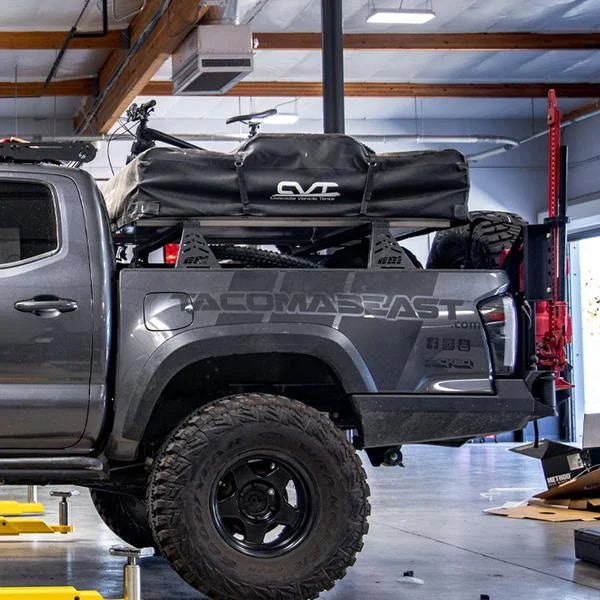 Toyota Tacoma overland bed bars with rooftop tent and off-road gear installed in a garage