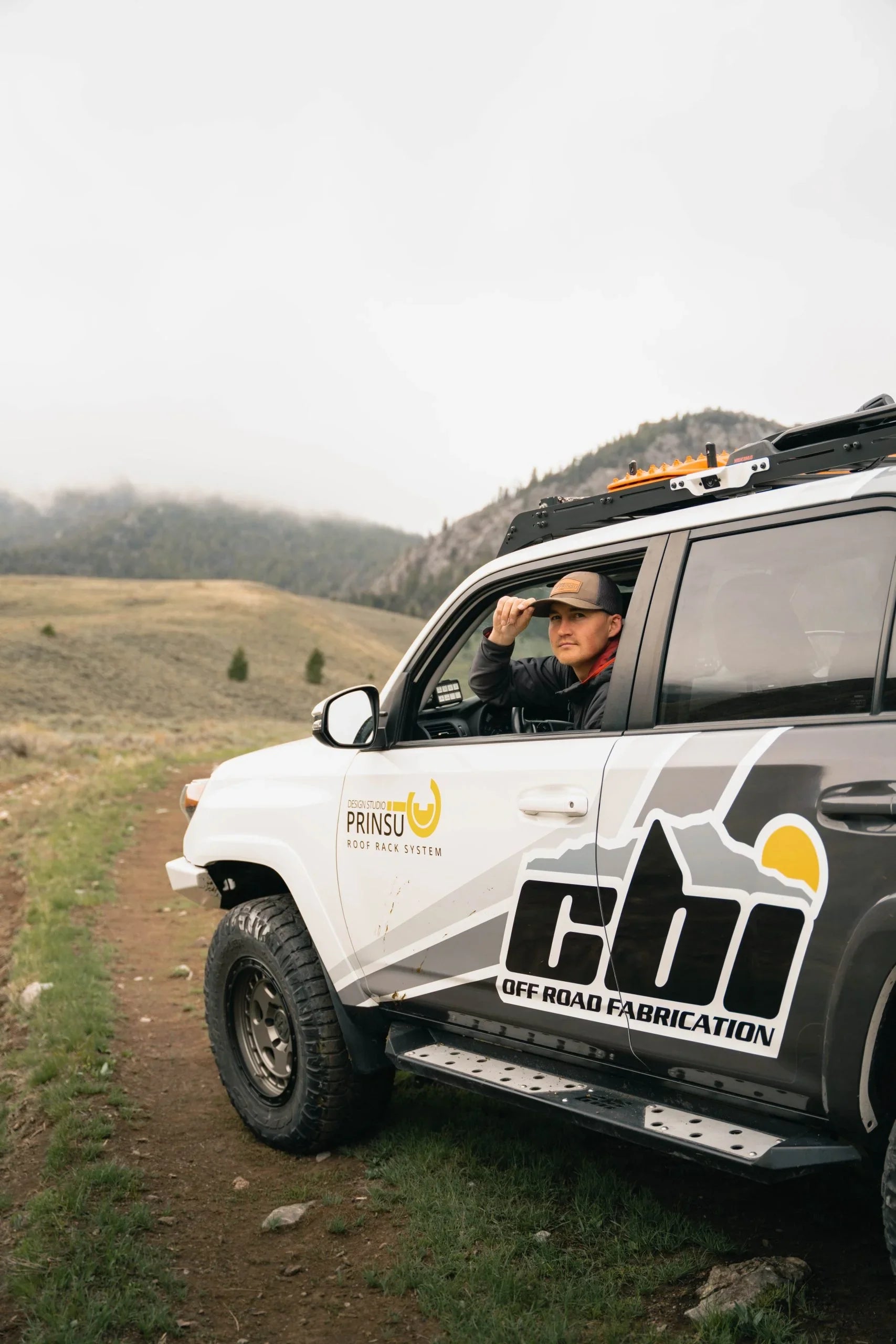 Toyota 4Runner with off-road side steps and roof rack parked on a mountain trail