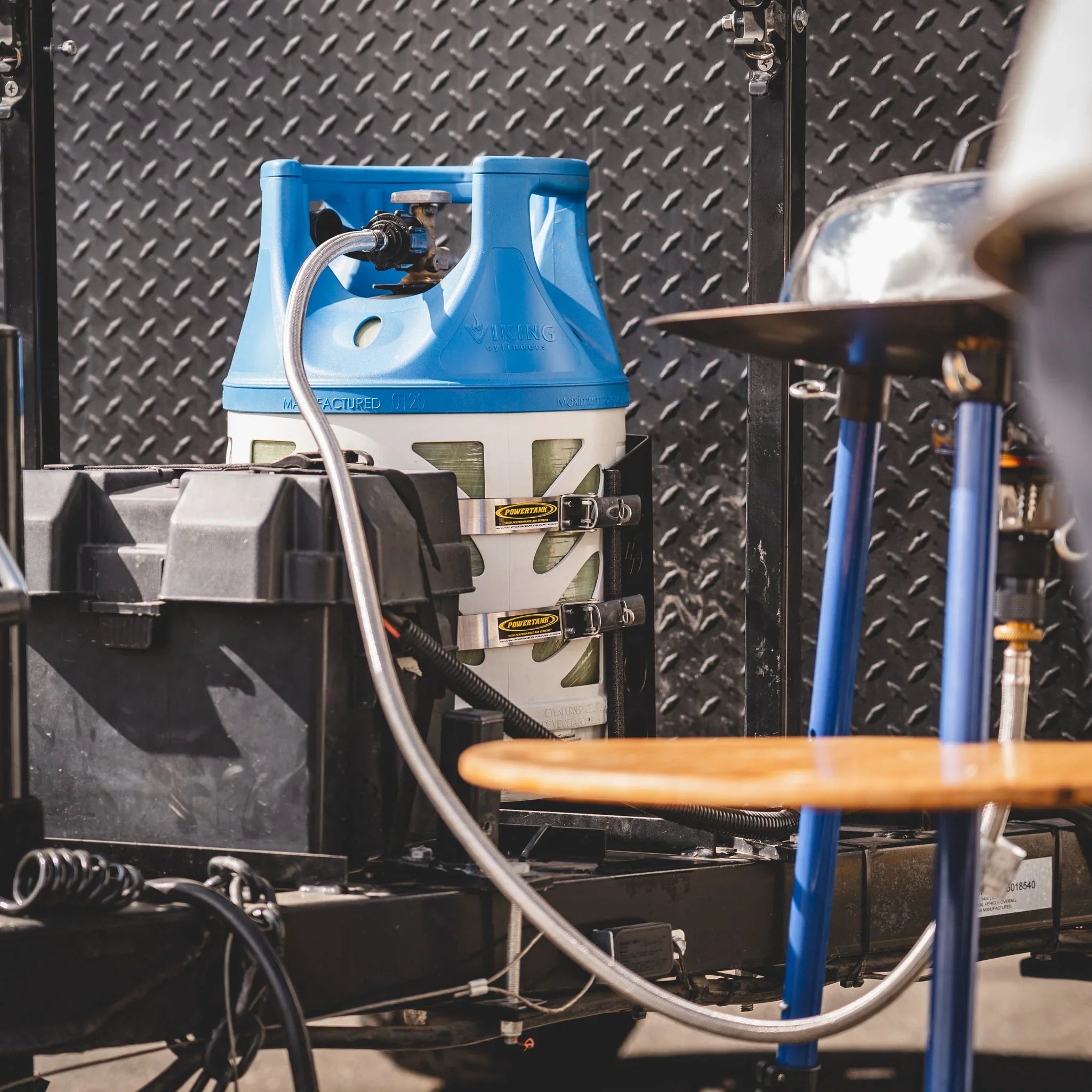 Overland camping propane tank securely mounted with hose and accessories on vehicle trailer