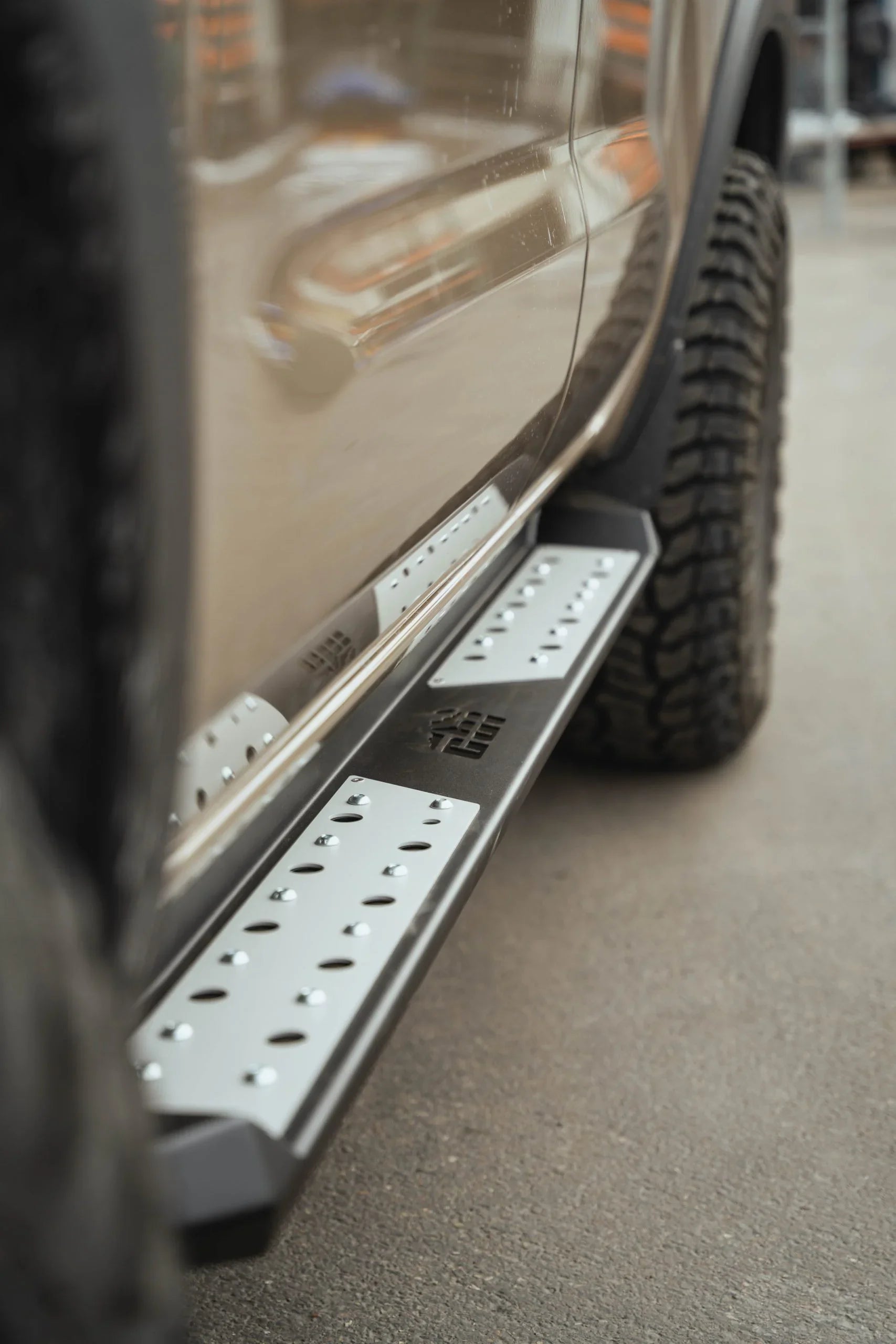 Close-up of rugged off-road truck with metal rock slider and all-terrain tires
