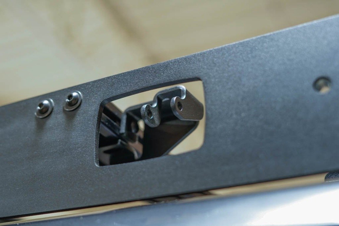 Close-up of a black metal mounting bracket for overlanding or vehicle roof rack.