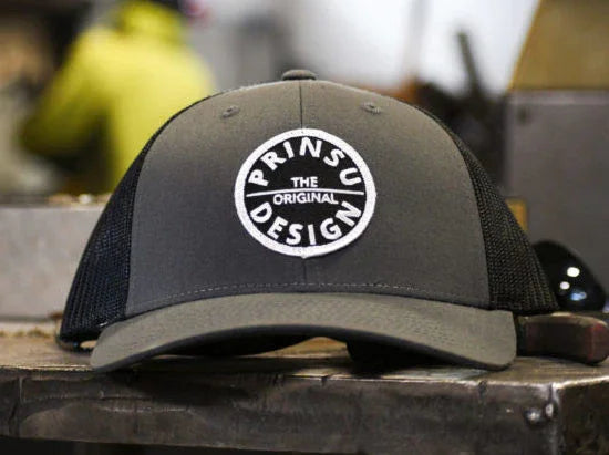 Gray and black trucker hat with Prinsu Design logo, for overlanding and expedition gear