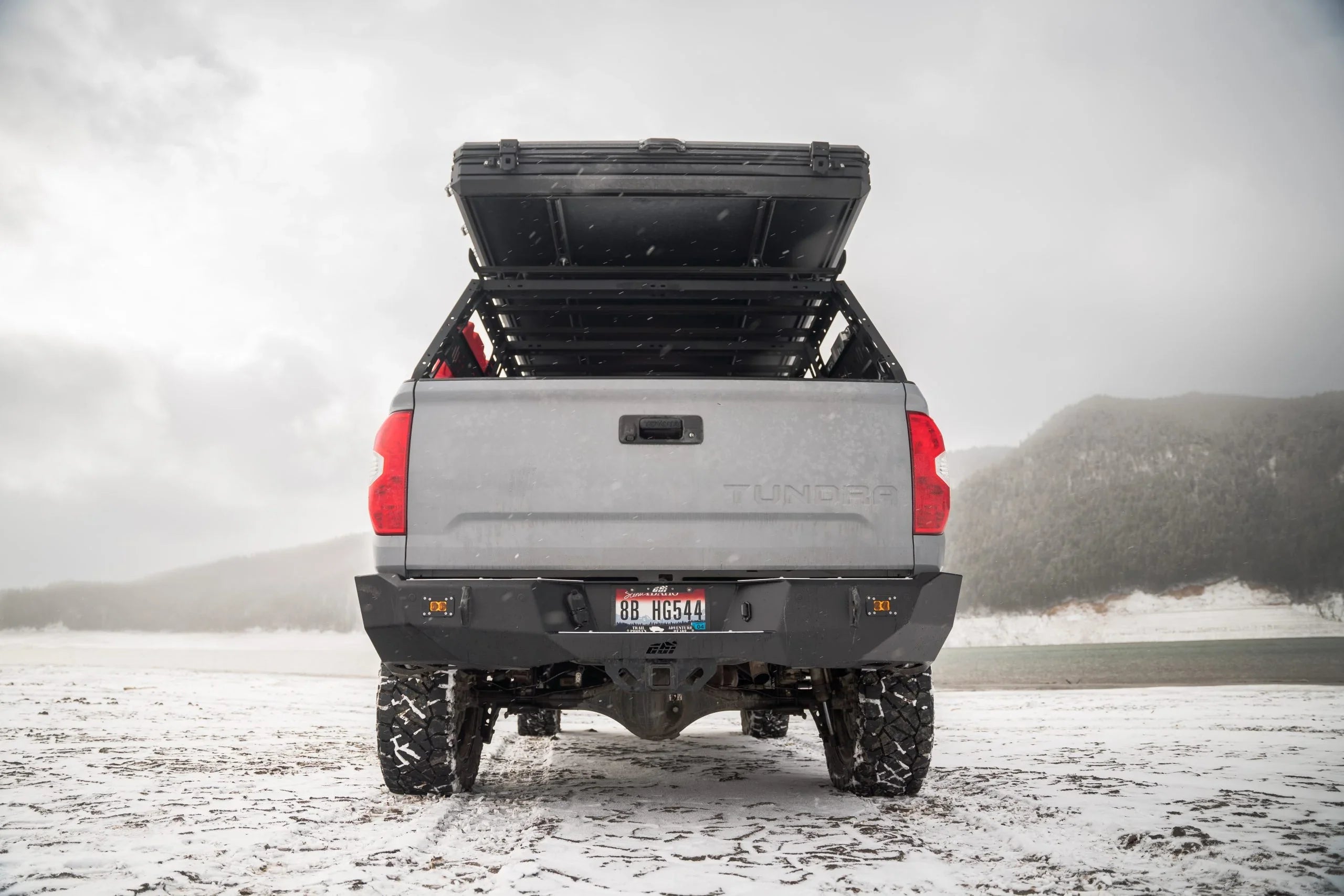 Toyota Tundra with overlanding bed rack and rooftop storage in snowy outdoor setting