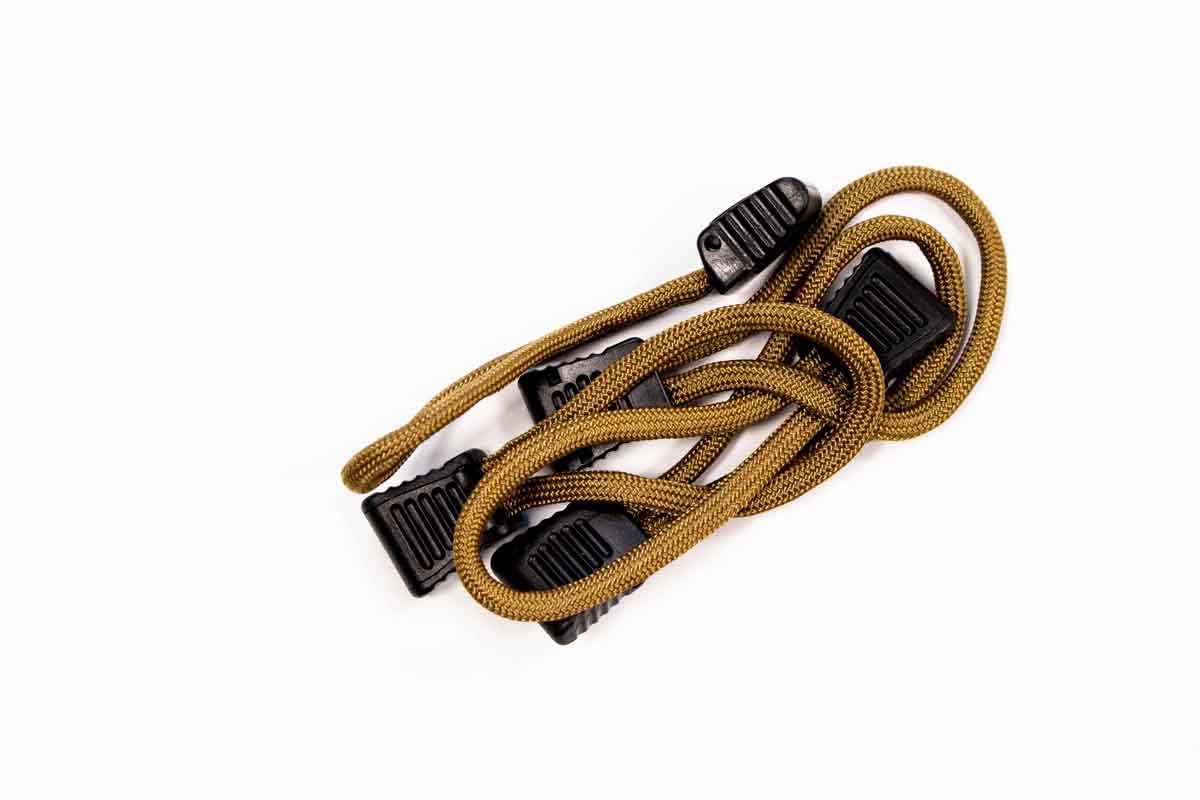 Tan bungee cord with black plastic hooks for overlanding and camping gear organization