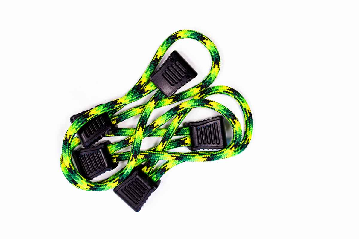 Green and yellow heavy-duty bungee cords with black hooks for overlanding gear organization