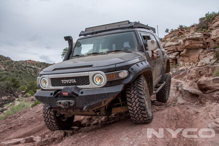 Toyota FJ Cruiser with roof rack and off-road accessories on rocky trail