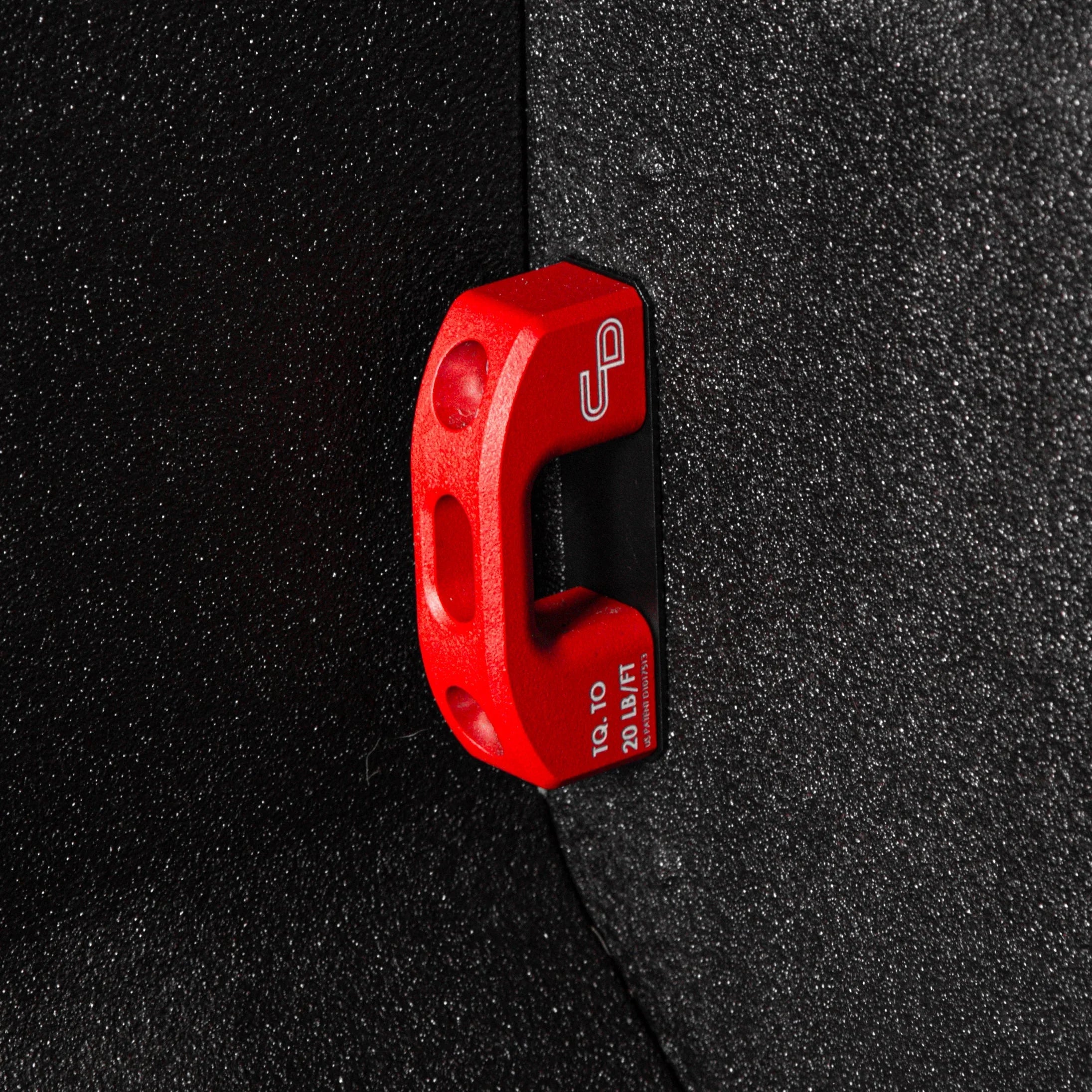 Red powder-coated bed tie down installed on a textured truck bed wall