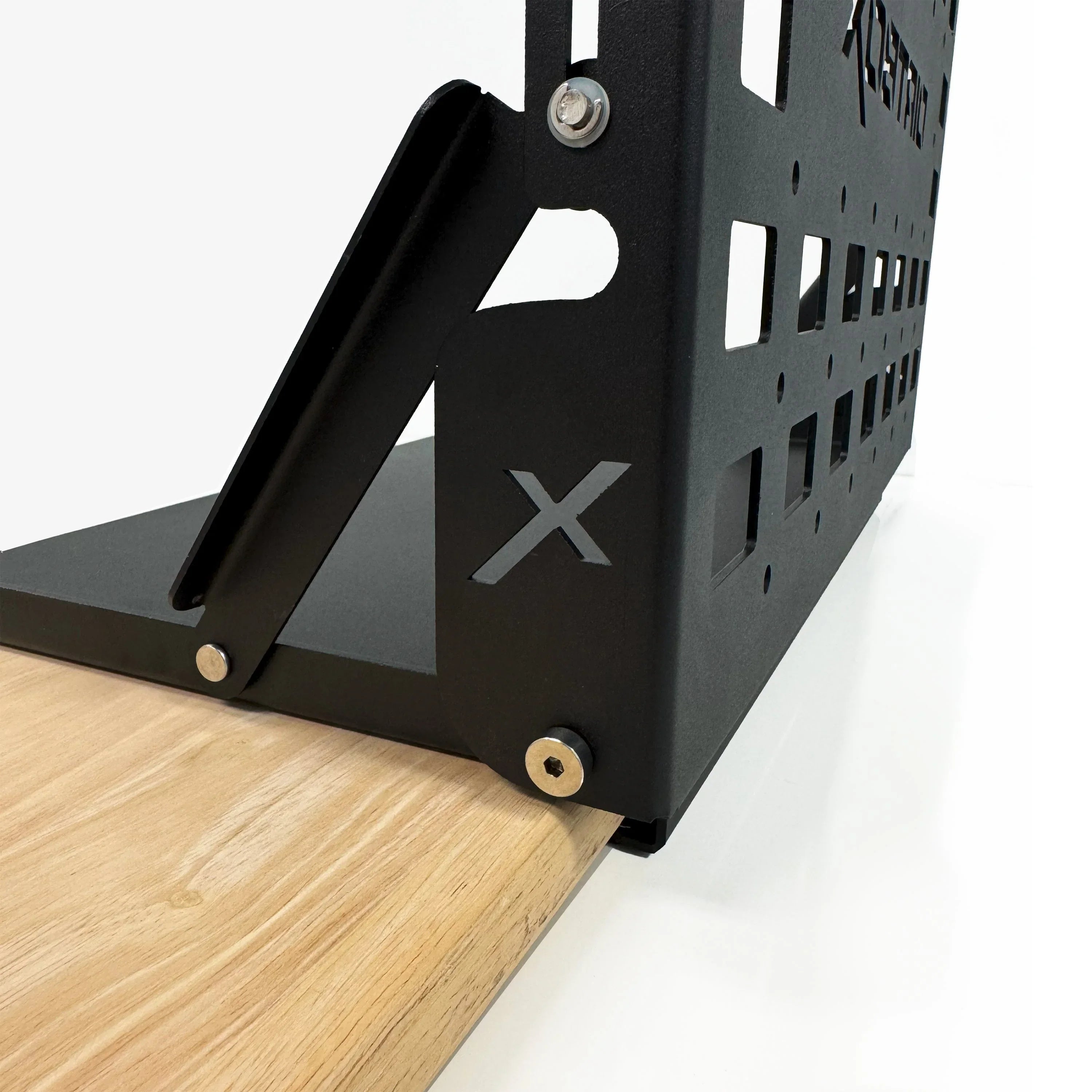 Steel overlanding accessory bracket with X cutout, mounted on wood, for vehicle gear storage