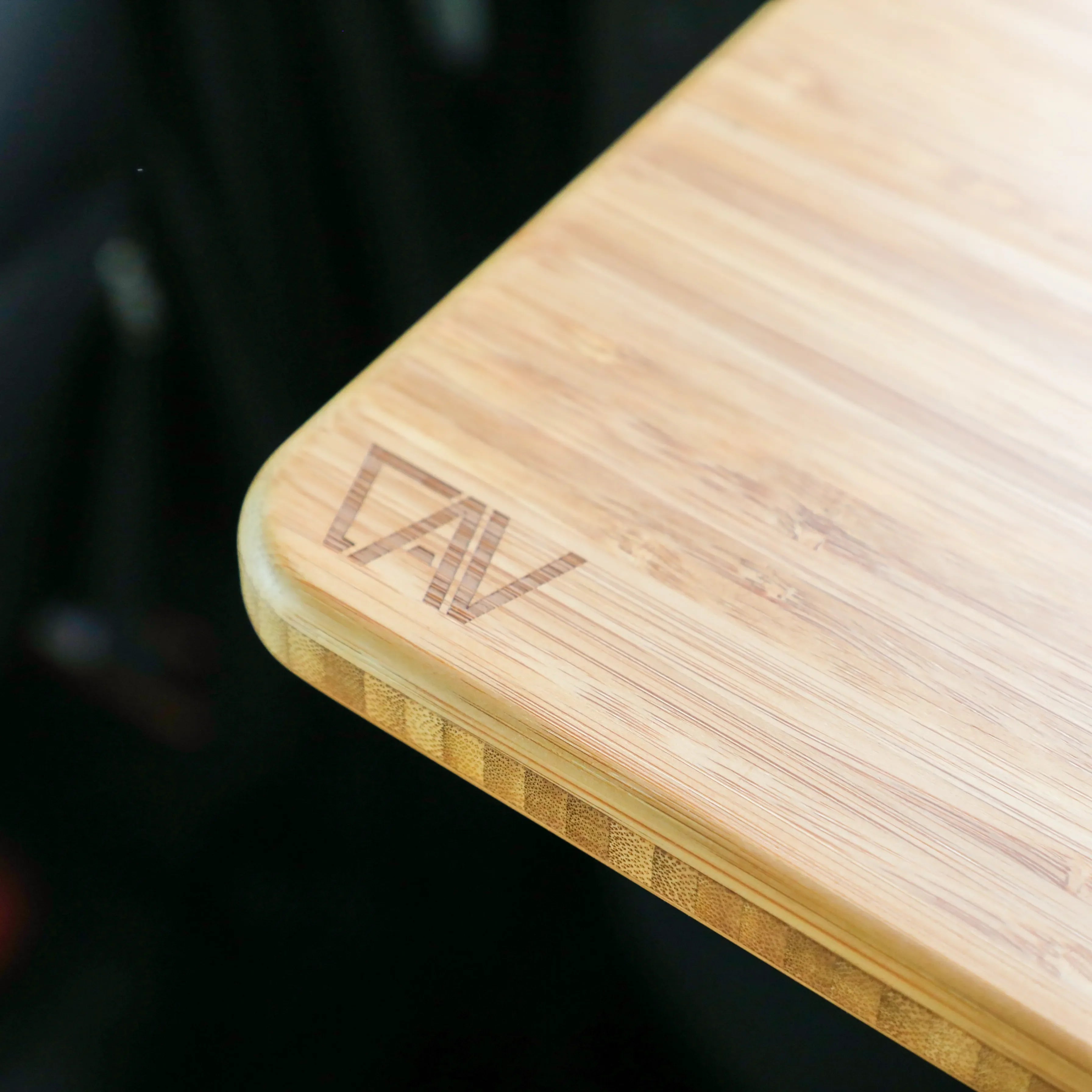 Close-up of bamboo folding countertop extension with rounded edge and engraved logo, ideal for camping