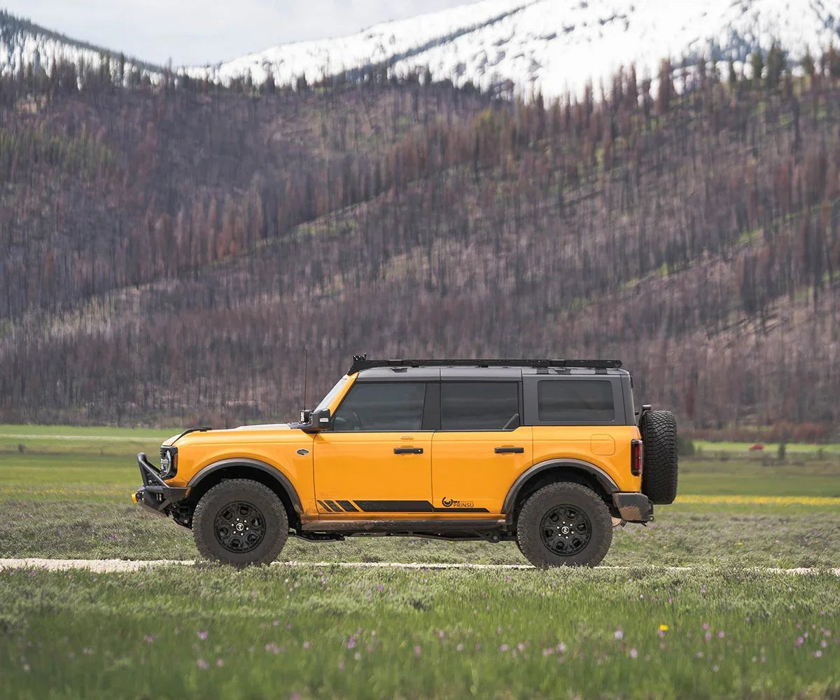 Yellow Ford Bronco with Prinsu roof rack parked outdoors, side view, off-road vehicle