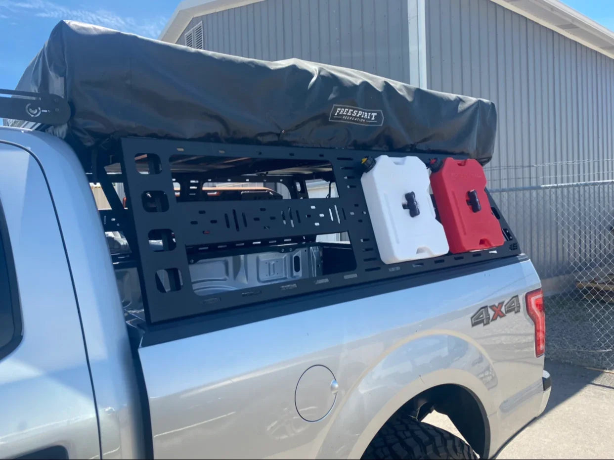 Ford F-150 with cab height bed rack, rooftop tent, and off-road gear containers