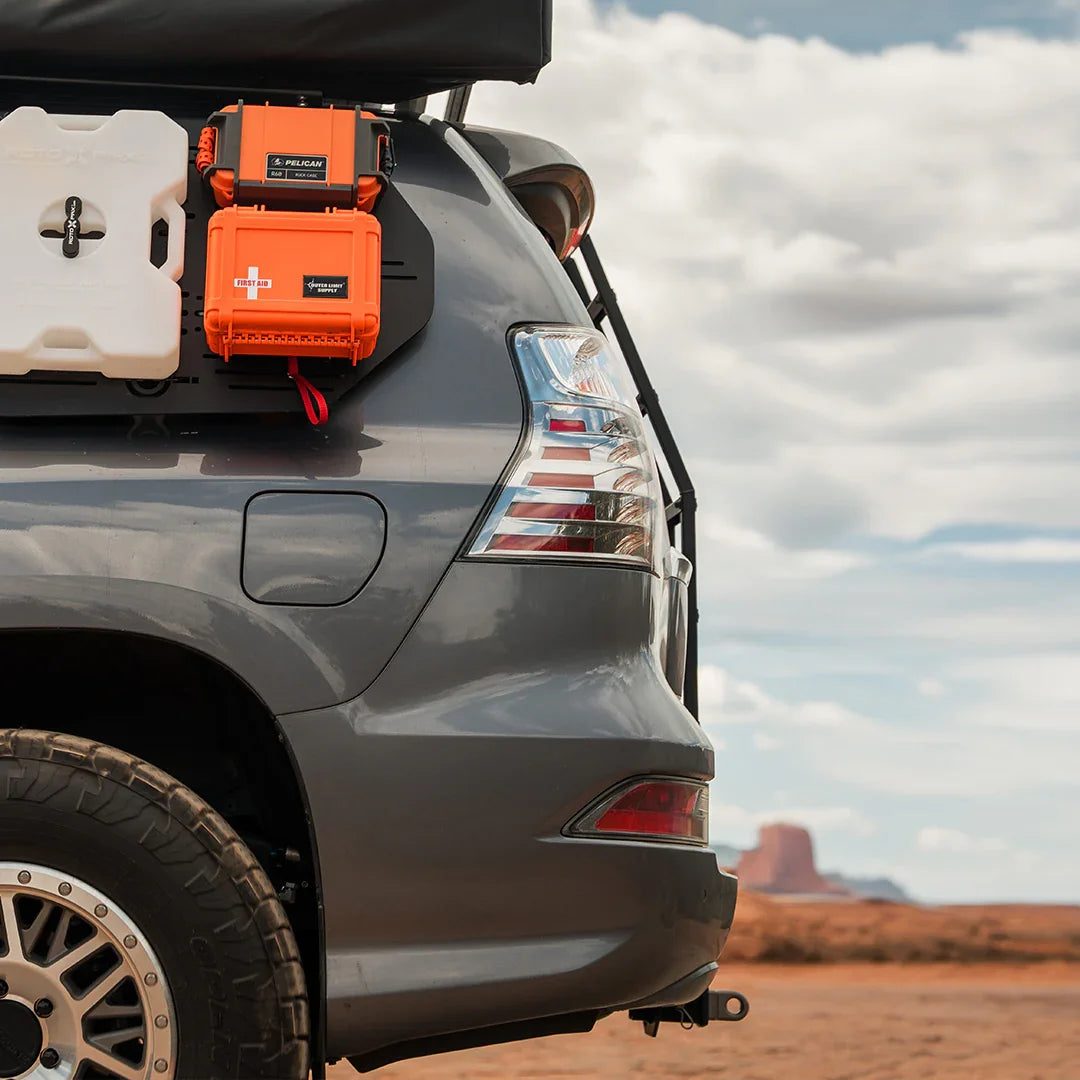 Overland GX460 SUV rear with ladder, RotopaX fuel can, Pelican case, desert backdrop