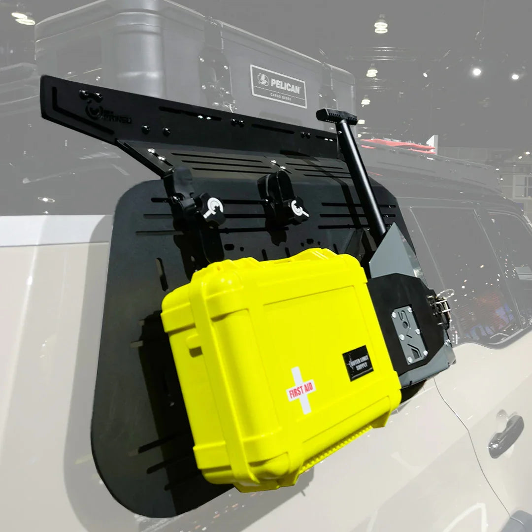 Overland vehicle storage panel with mounted yellow first aid case and accessories