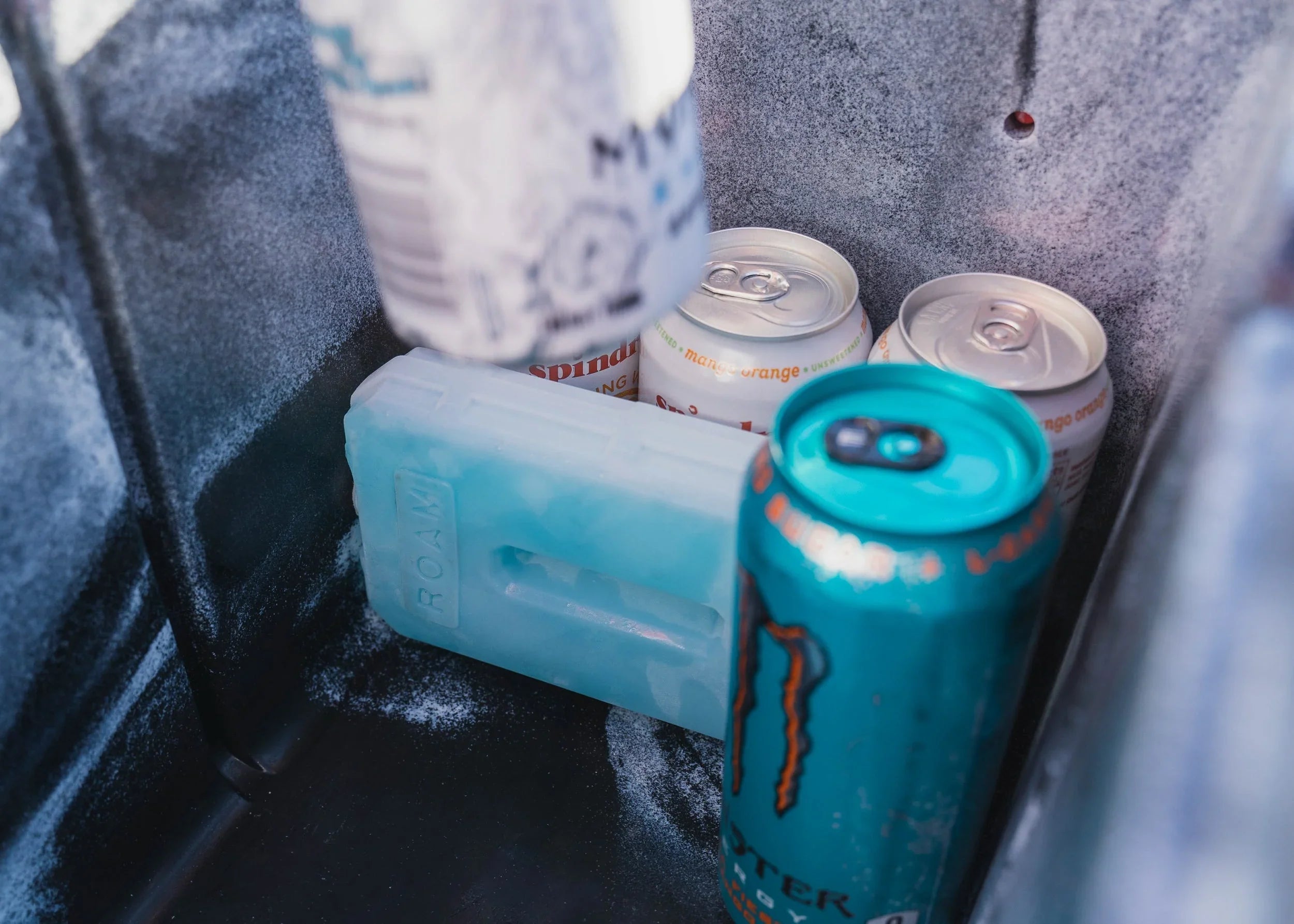 Close-up of canned drinks and ice pack inside an insulated camping cooler