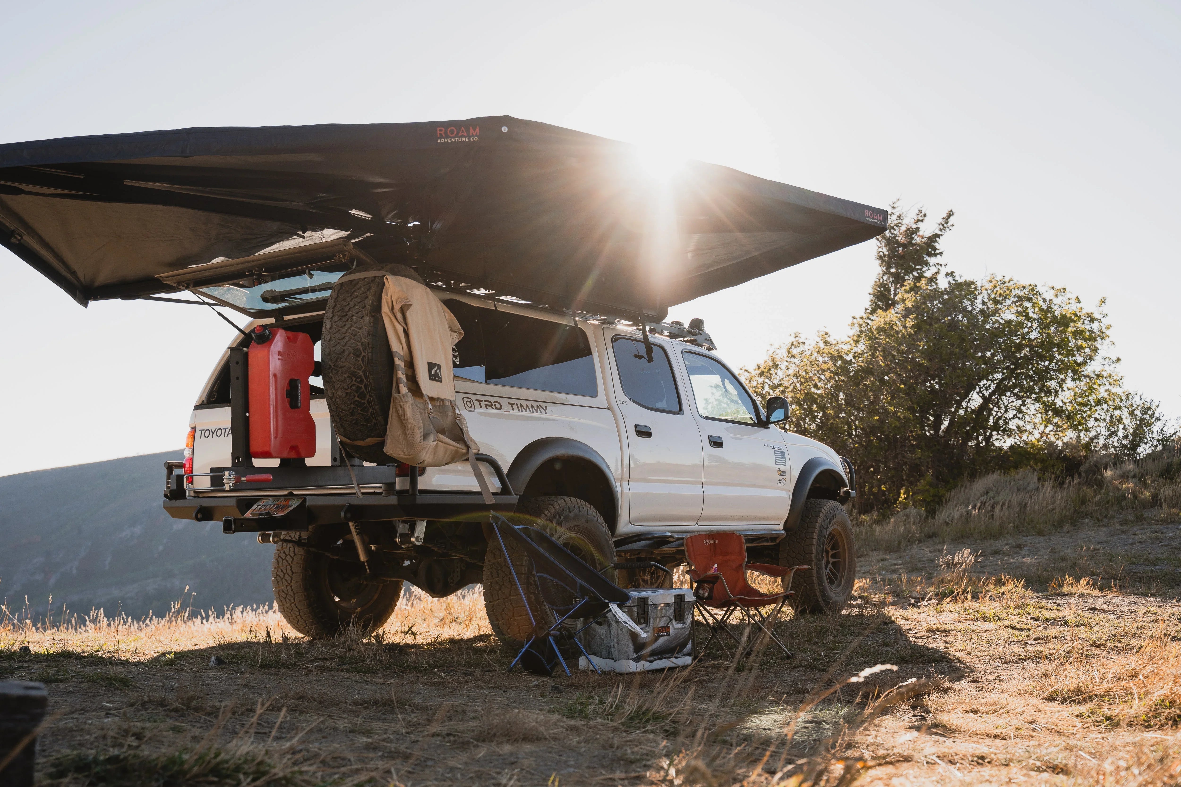Overlanding Toyota Tacoma with roof awning, recovery gear, and camping setup outdoors