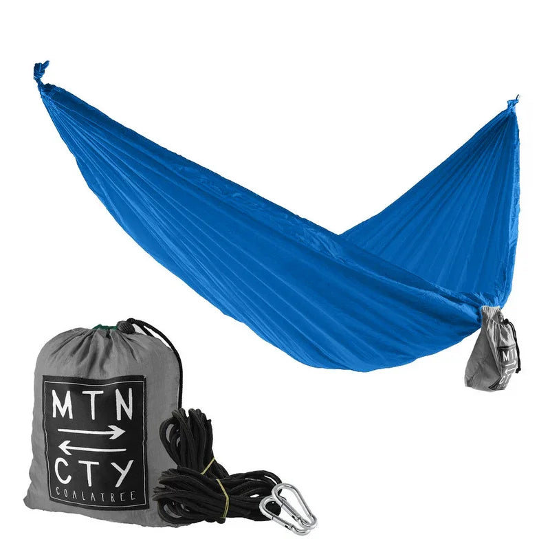 Blue camping hammock with gray carry bag, rope, and carabiners for outdoor adventure