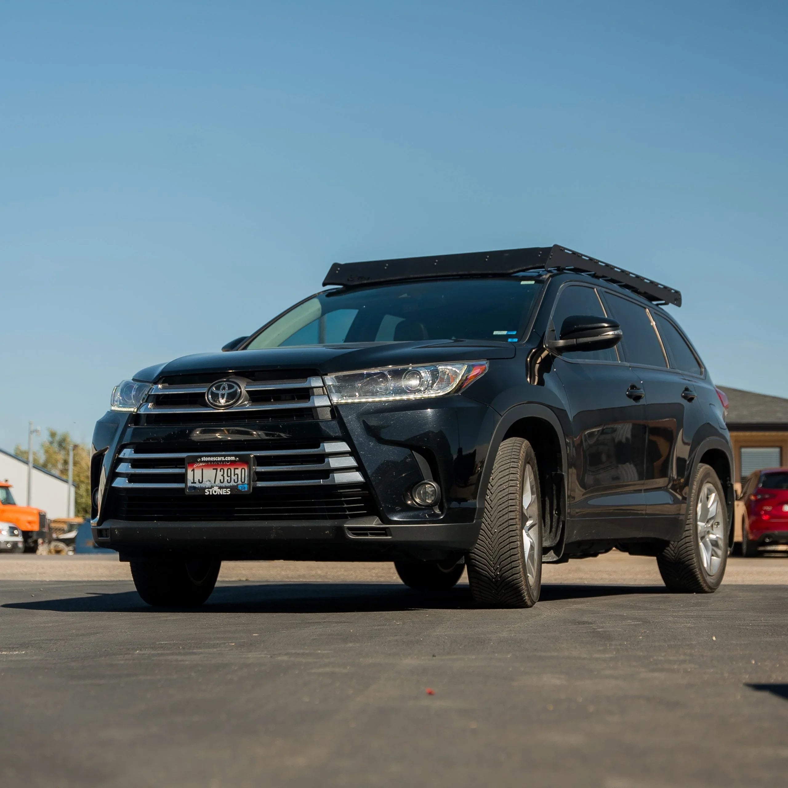 Black Toyota Highlander with roof rack for overlanding and adventure gear parked outdoors