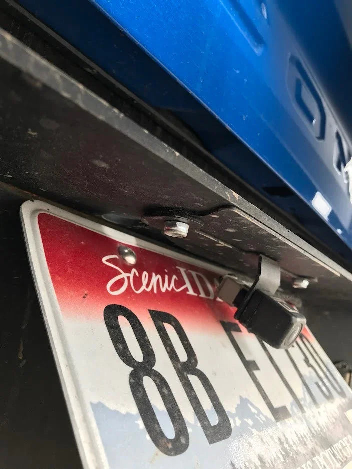 Close-up of blue vehicle tailgate, Idaho license plate, and backup camera mount