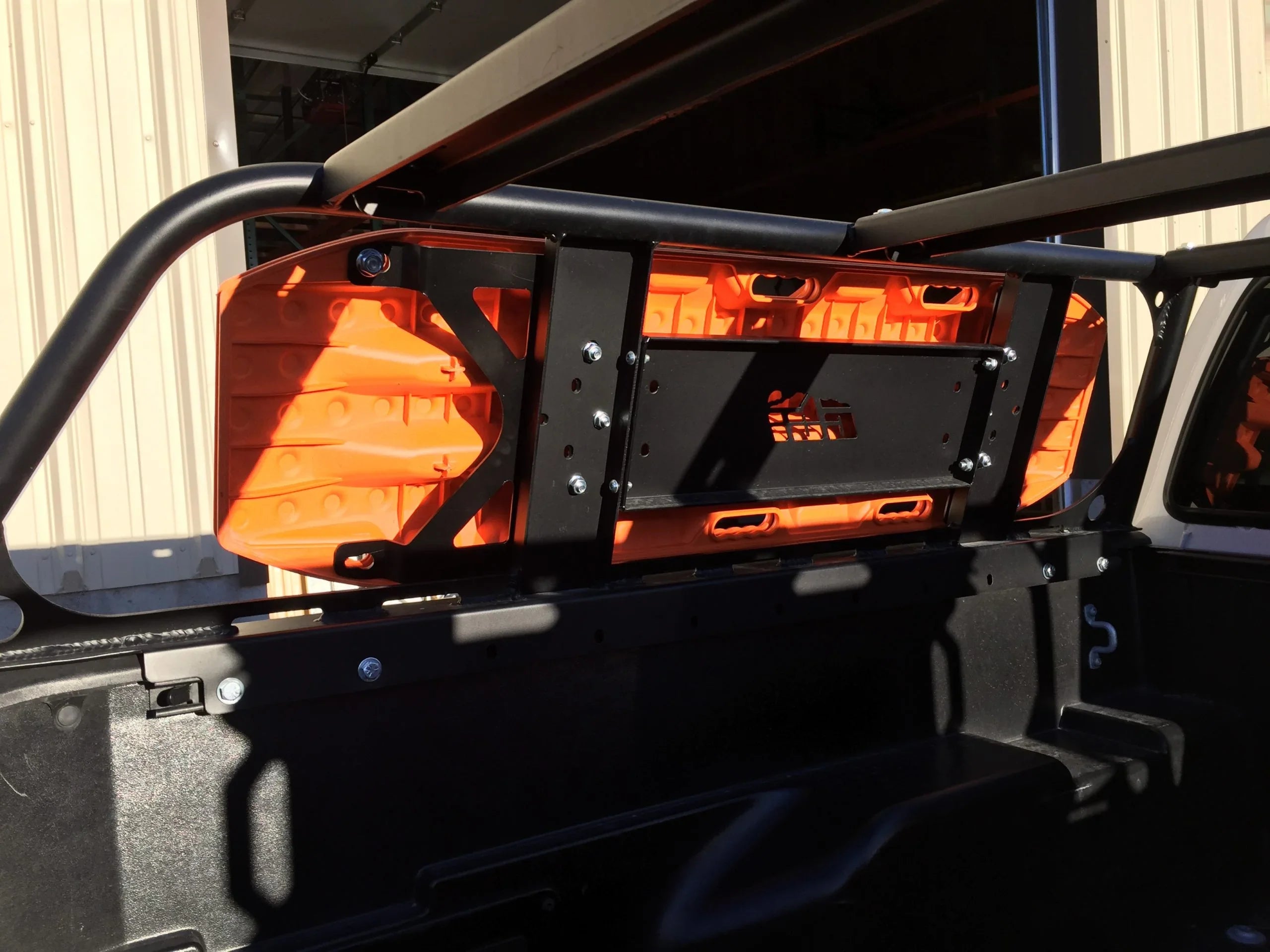 Orange recovery boards mounted on a truck bed rack for overlanding and off-road vehicles