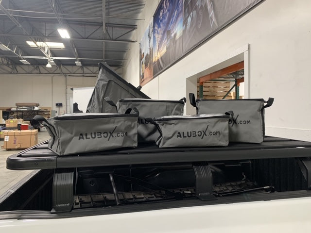 Set of four ALUBOX storage gear bags on roof rack of pickup truck for overlanding