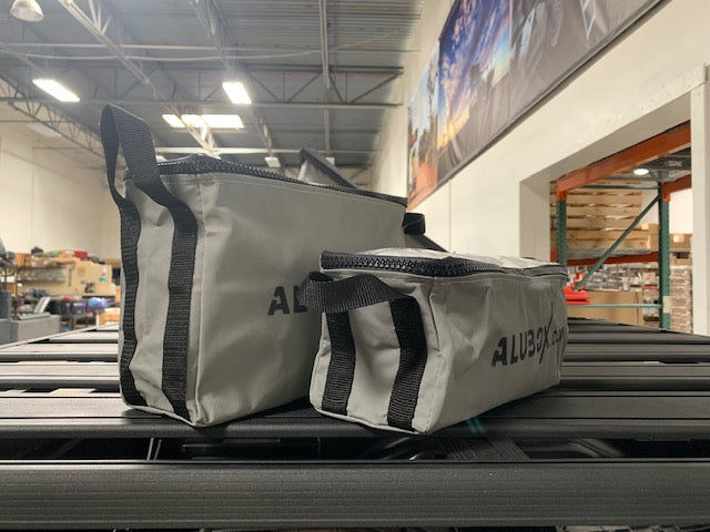 Two gray ALUBOX storage bags on a roof rack, ideal for overlanding gear organization