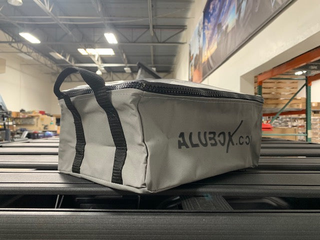 Gray ALUBOX gear bag with zipper on storage rack, ideal for overlanding accessories