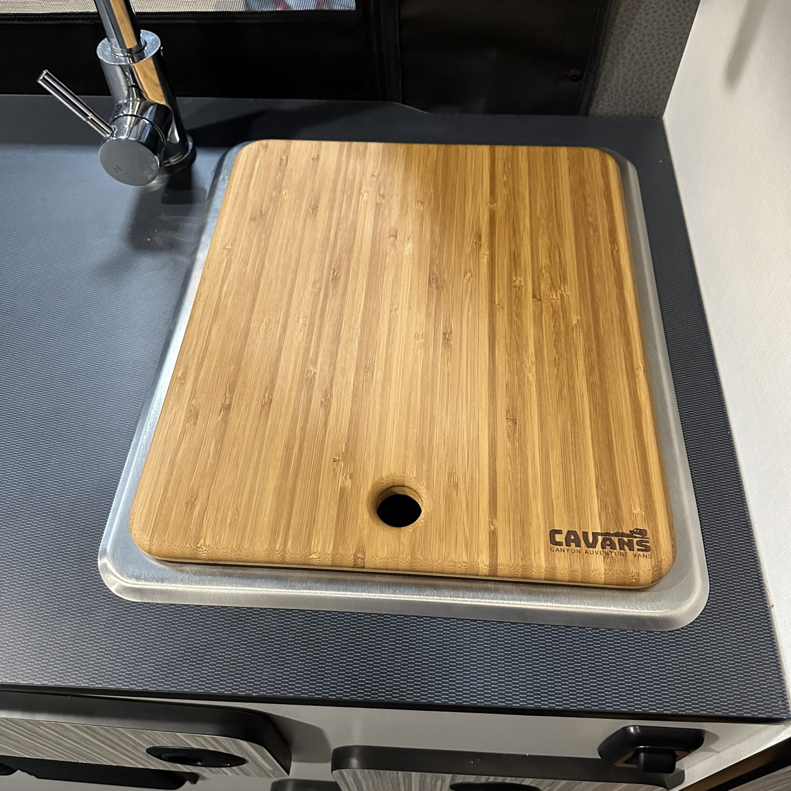 Bamboo cutting board with drainage hole on RV or camper kitchen sink