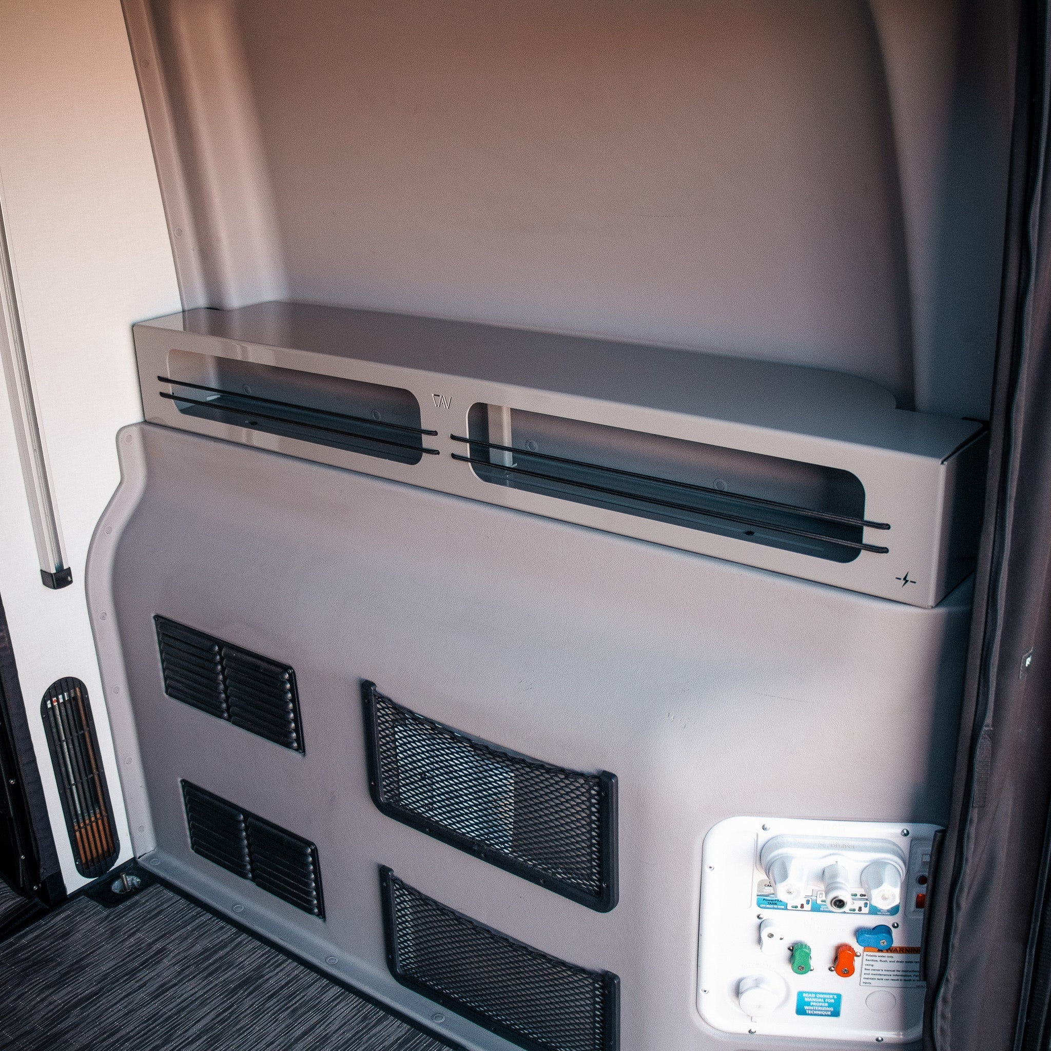 Interior view of overlanding camper van storage and utility panel setup