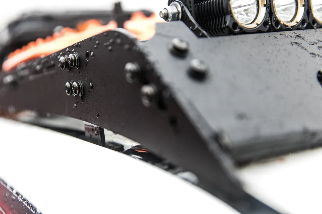 Close-up of overland vehicle roof rack with water droplets, LED lights, and recovery boards