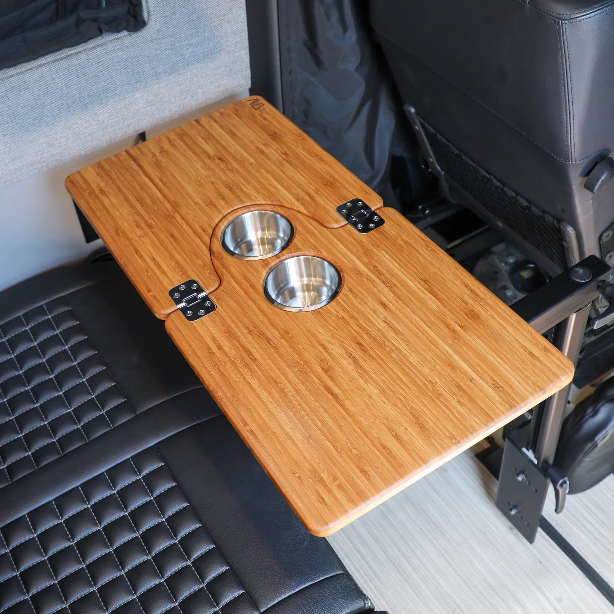 Bamboo folding vehicle table with dual cup holders installed in car interior.