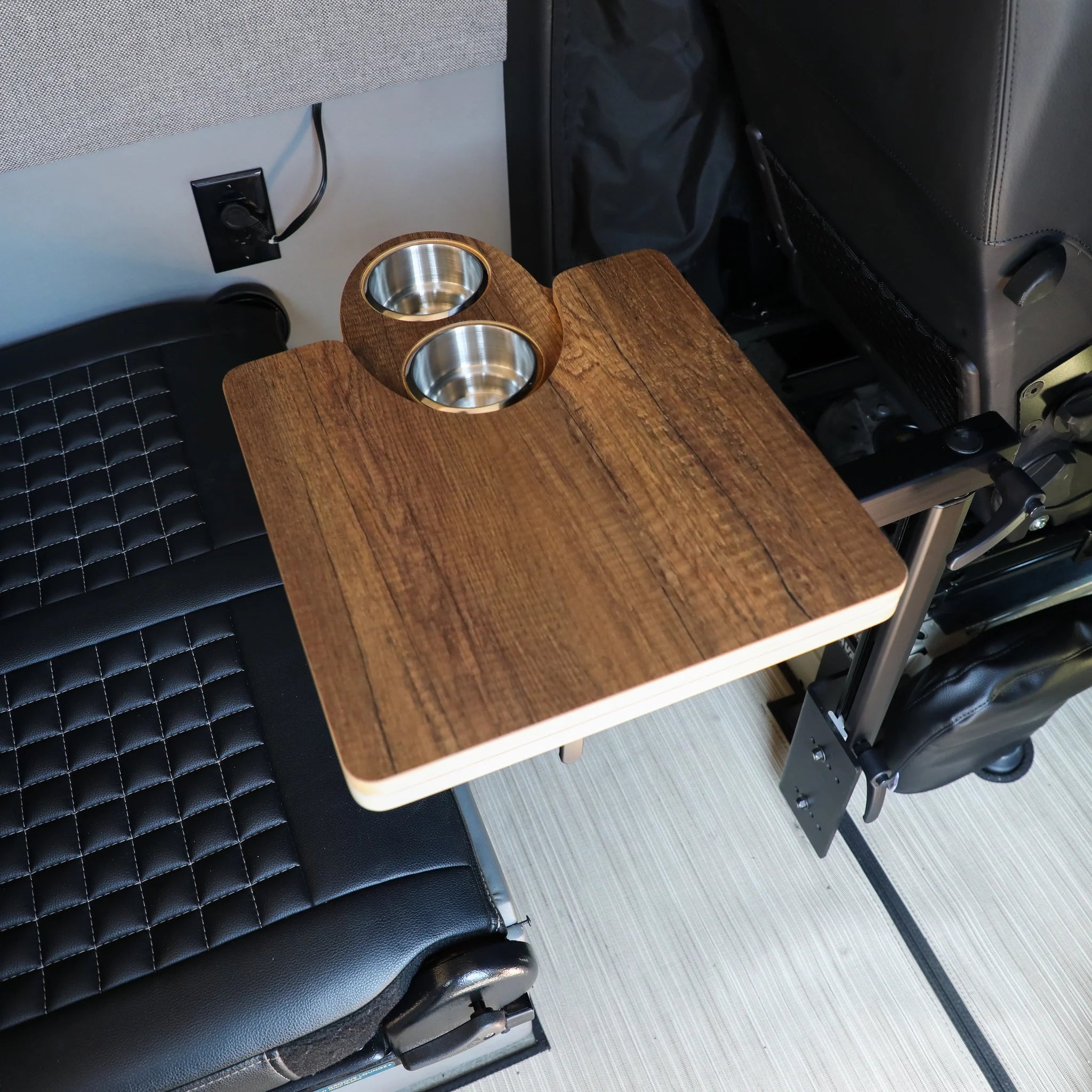 Wood grain vehicle mounting table with dual cup holders in an adventure van interior