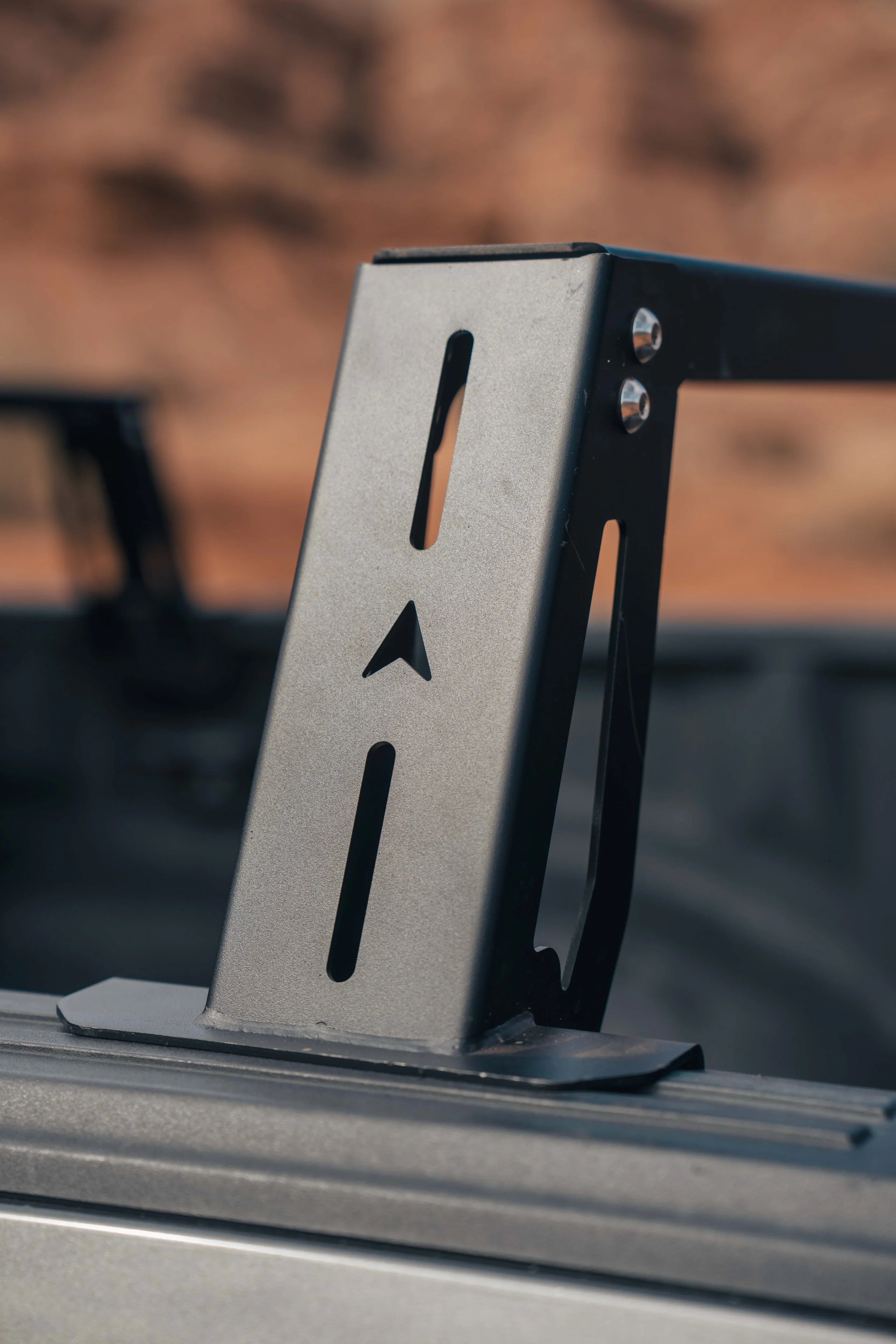 Close-up of a black overland truck bed rack mounting bracket with cut-out slots for Toyota Tacoma or 4Runner.